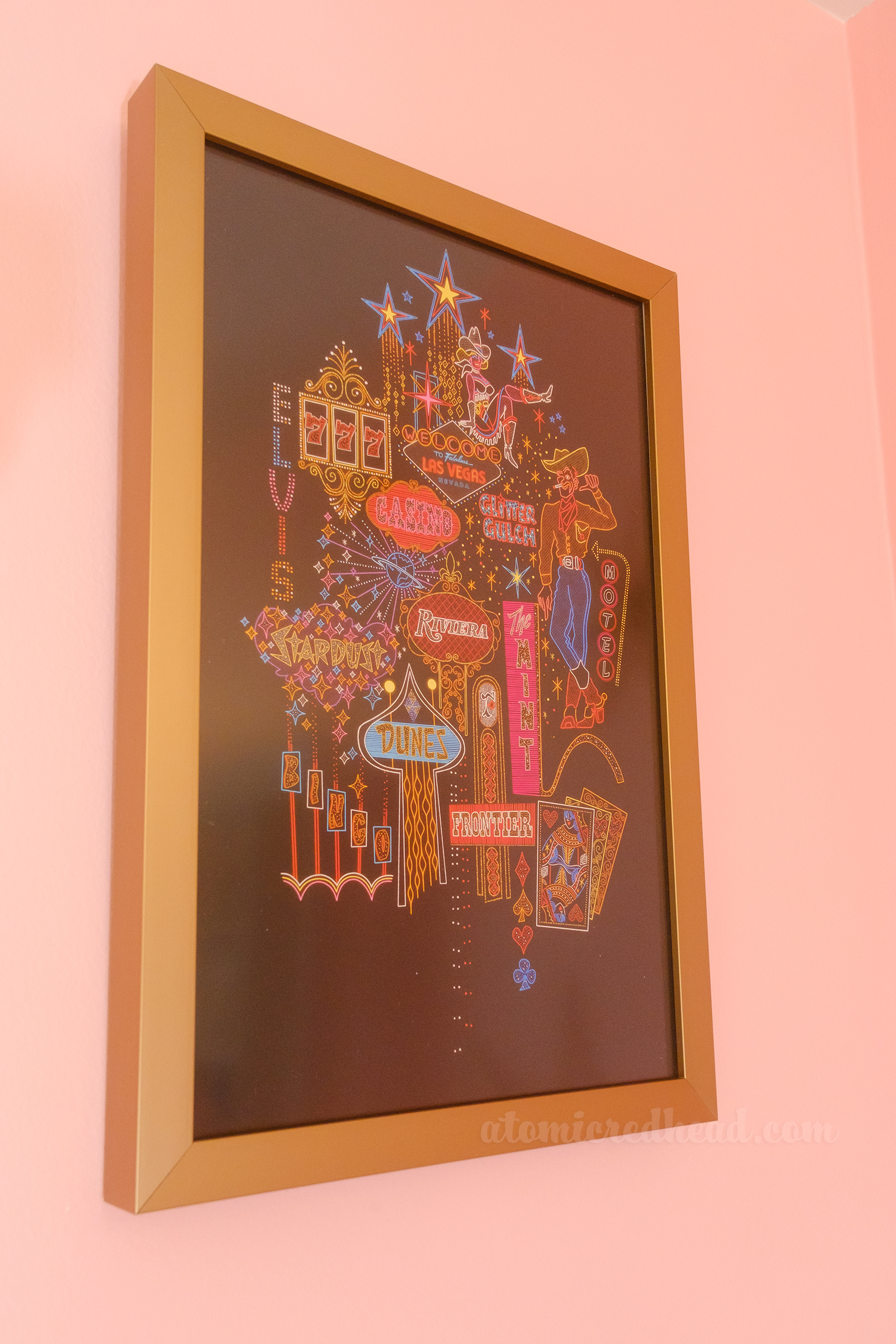 A colorful print featuring artistic interpretations of vintage Las Vegas signs, such as the iconic "Welcome to Fabulous Las Vegas" sign, Glitter Gulch, Stardust, Dunes, and The Mint.