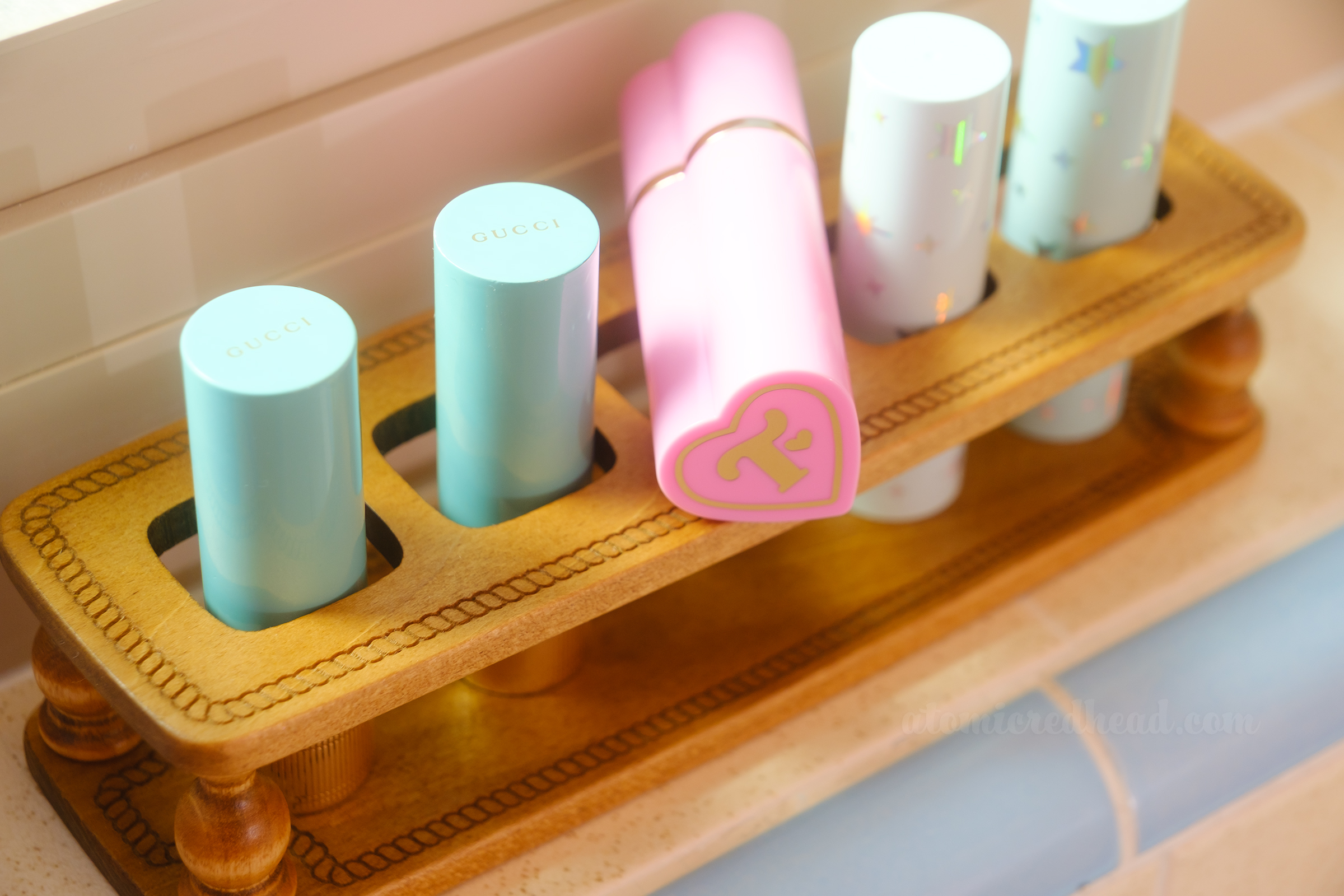 Close-up of a wood lipstick holder, which contains several lipstick tubes.