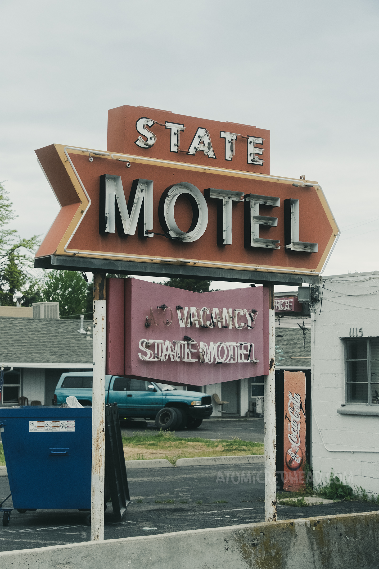 A red, white, and yellow neon sign reading "State Motel"