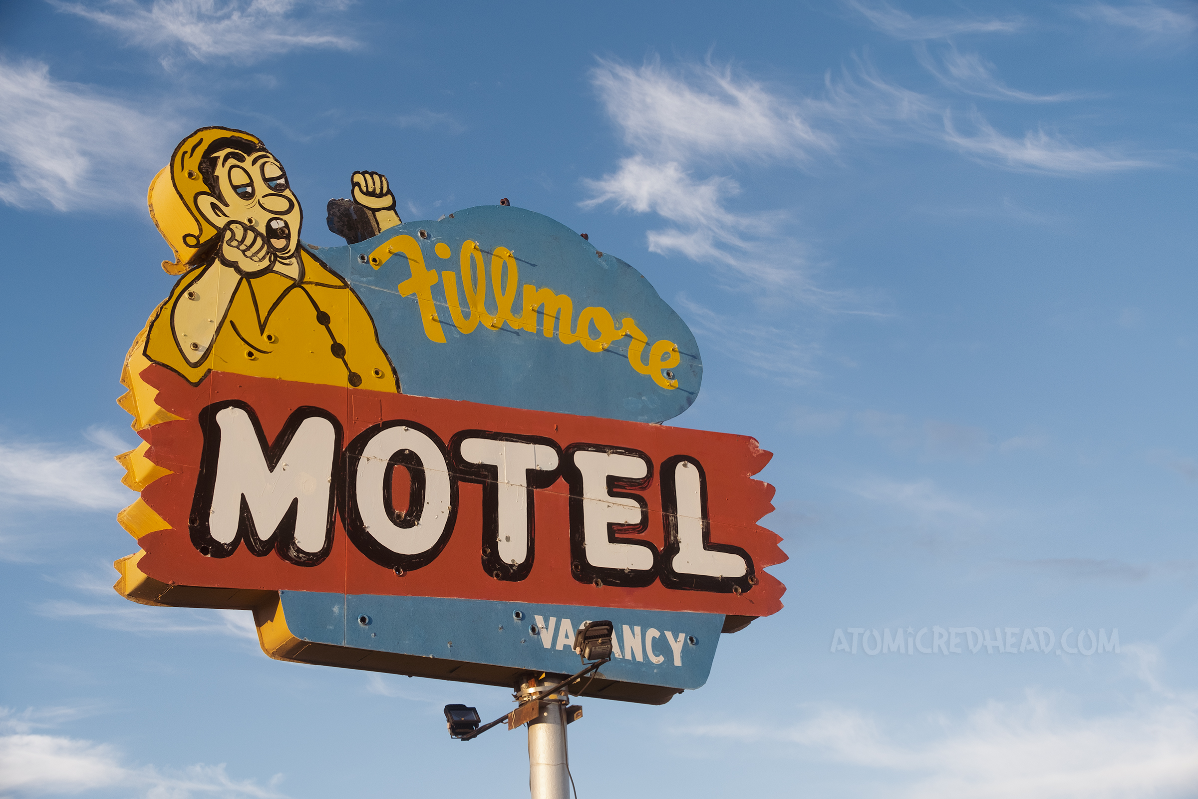 A sign featuring a yawning man in pajamas reads "Fillmore Motel"