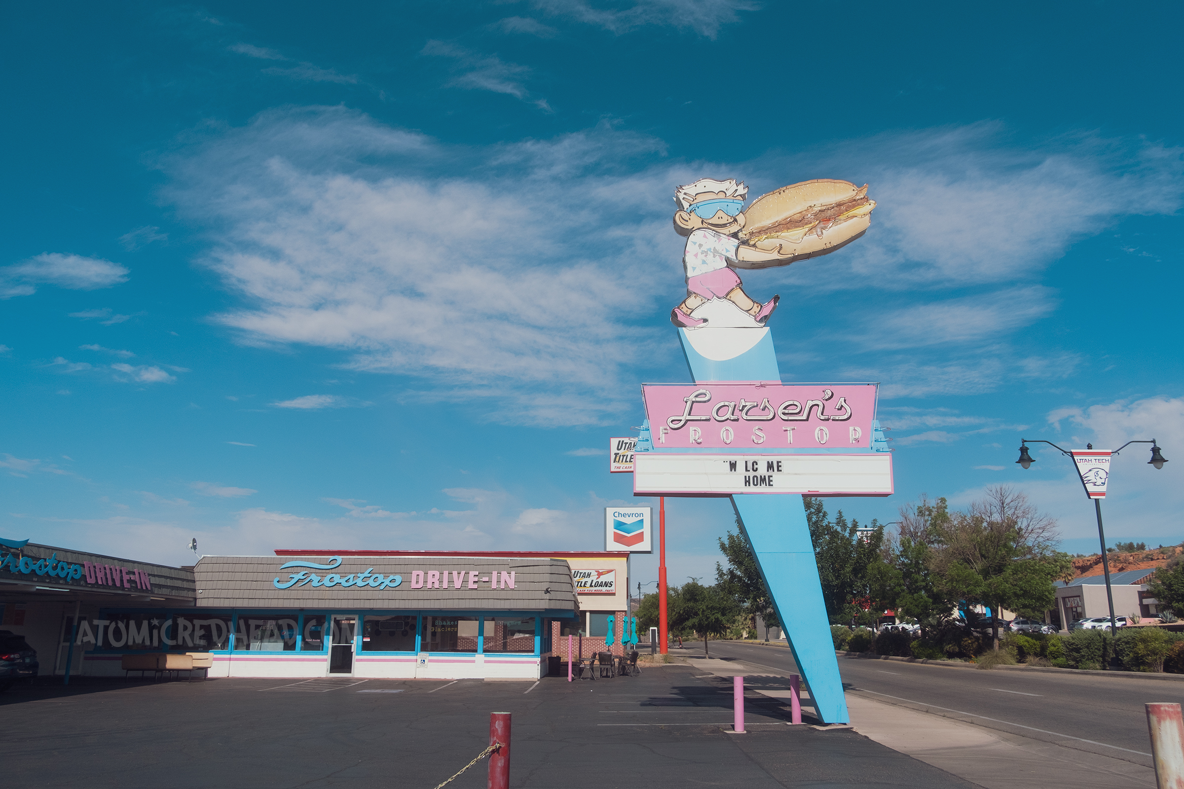 A large neon sign features a boy carrying a massive burger and below reads "Larsen's Frostop"