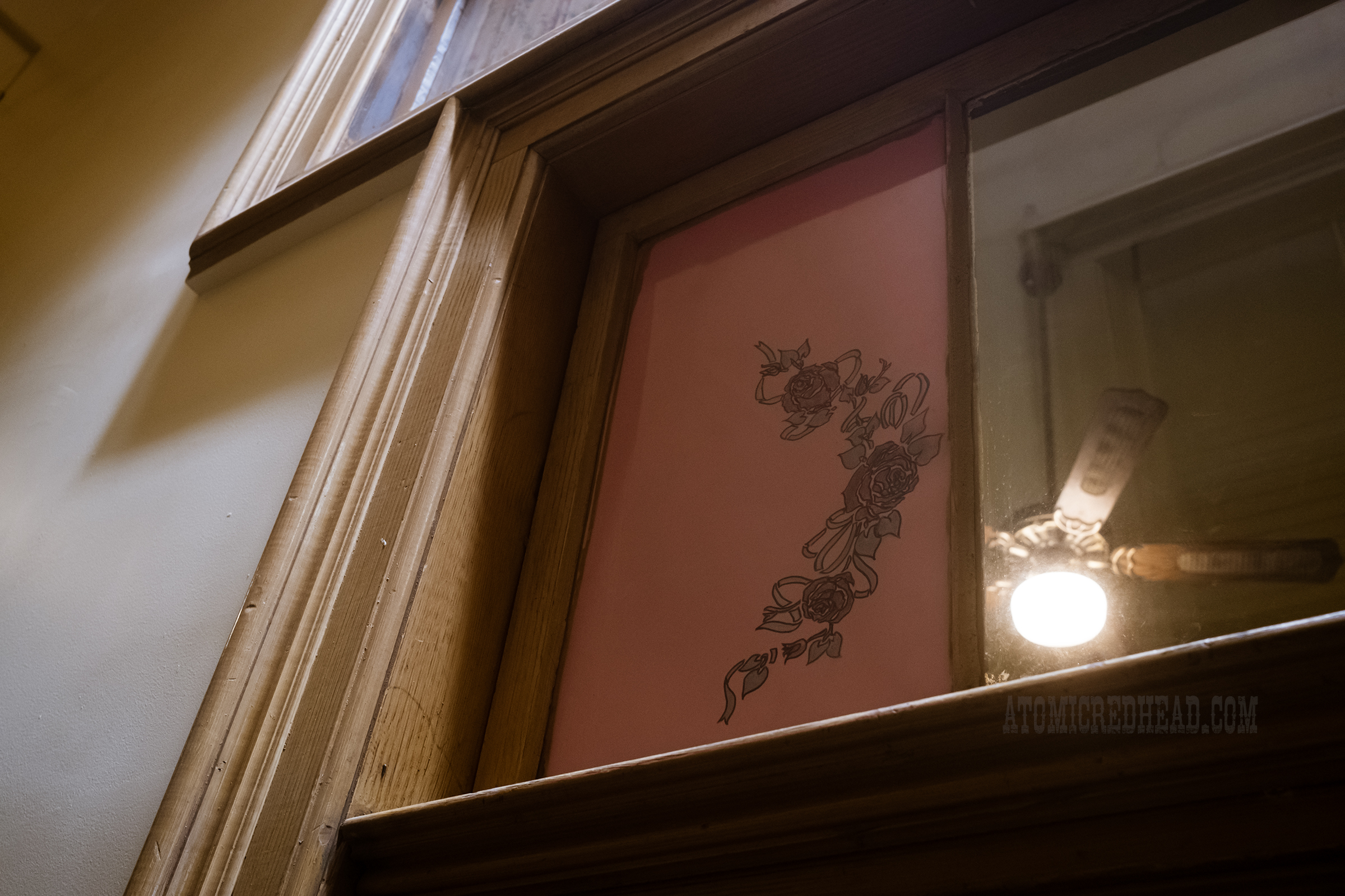Close-up of a rose design on the window above the door to room 11.