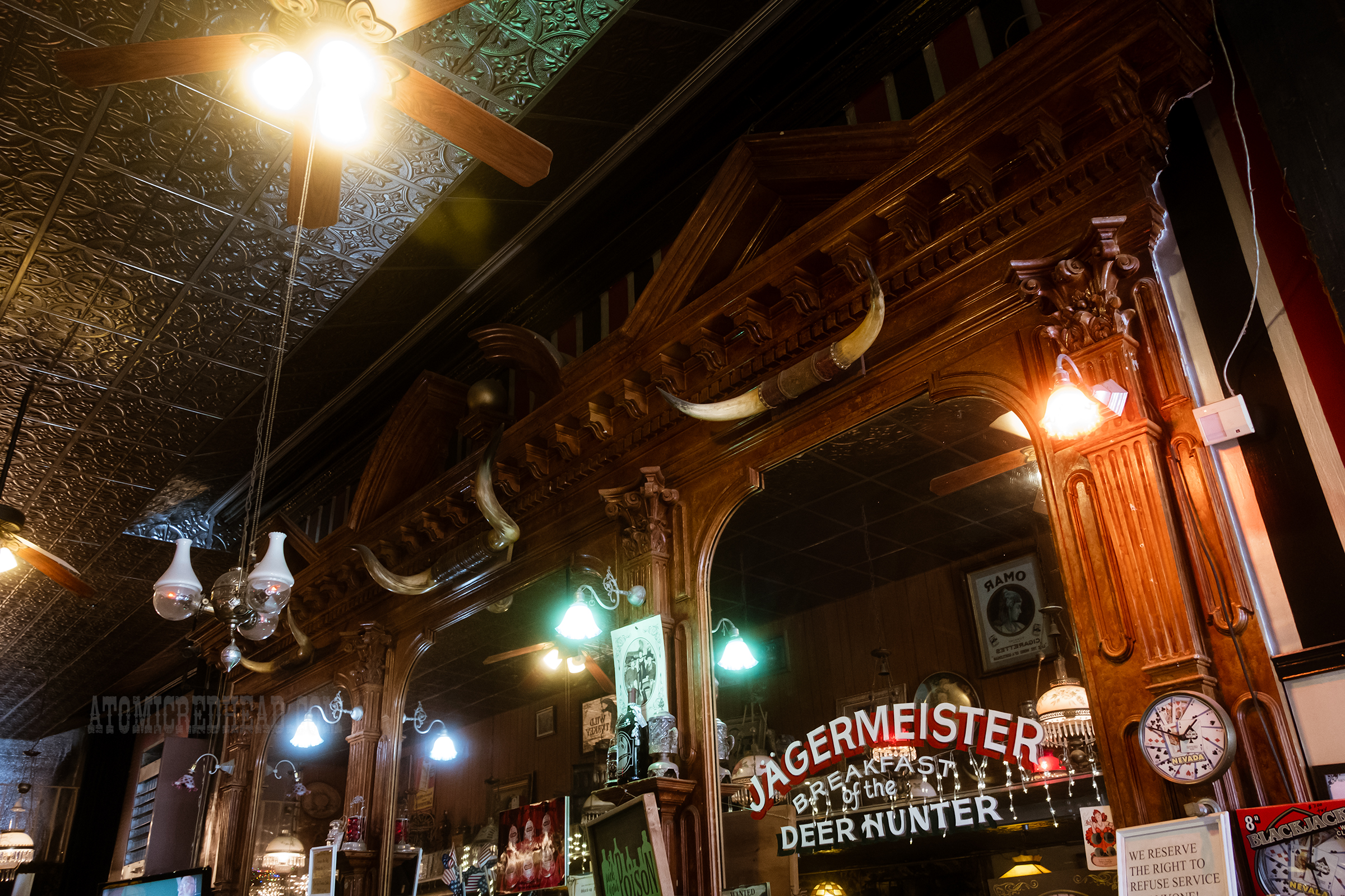 View of the bar back with mirrors and steer horns hanging above.