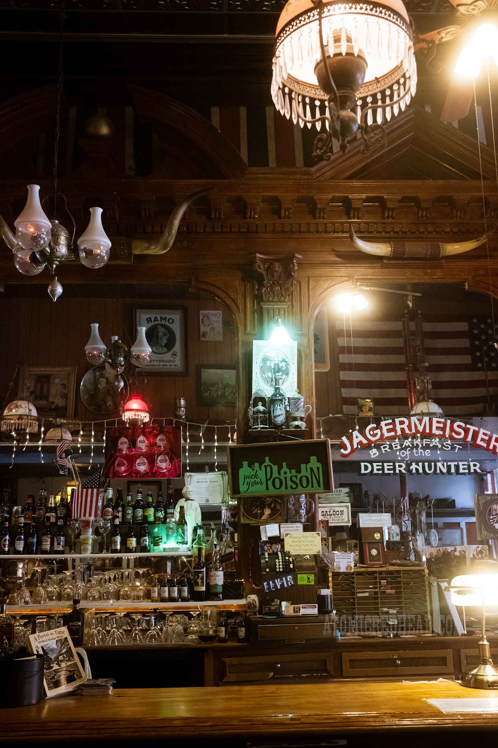 View of the bar back with mirrors and steer horns hanging above.
