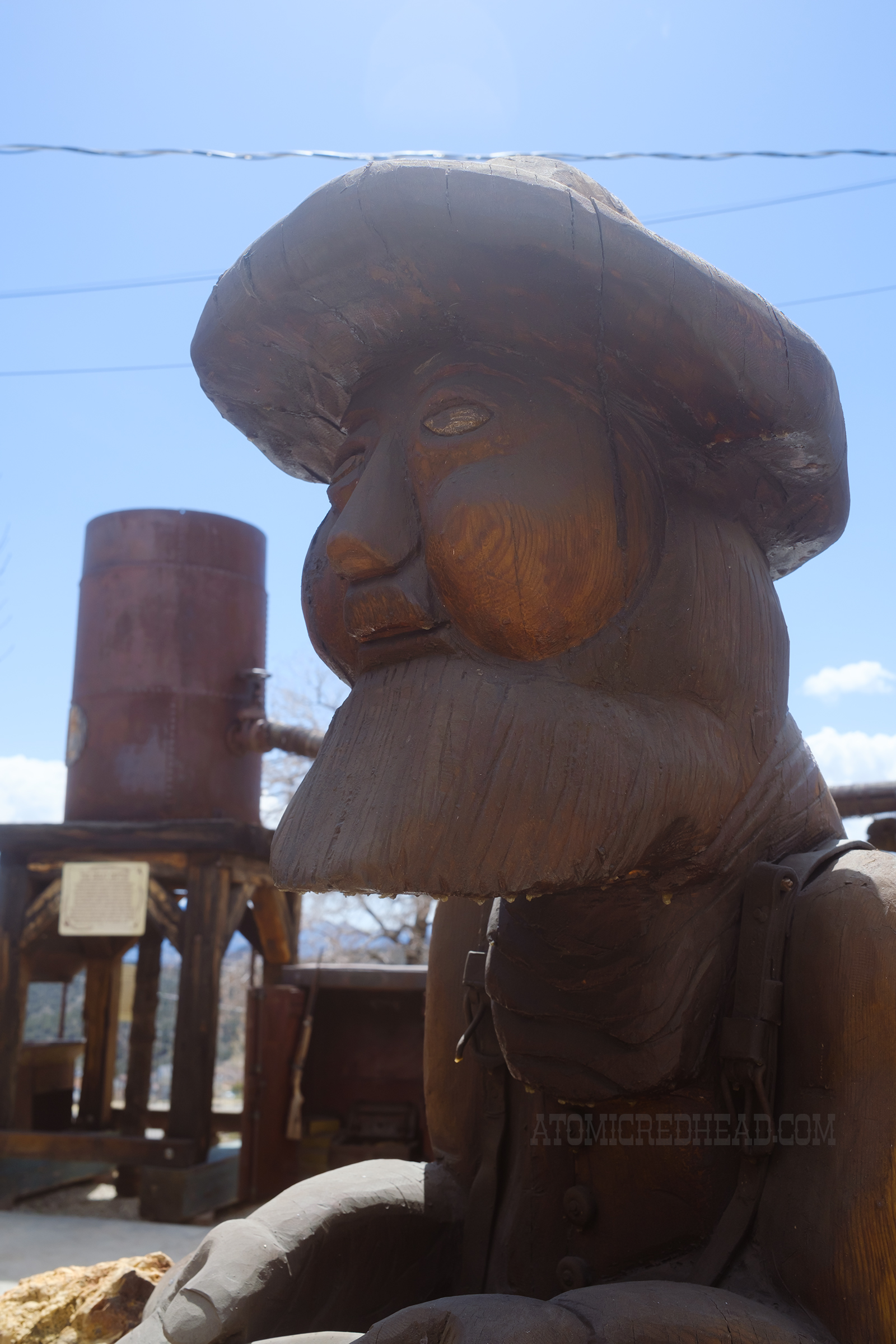 A carved wood minor sits outside the museum.