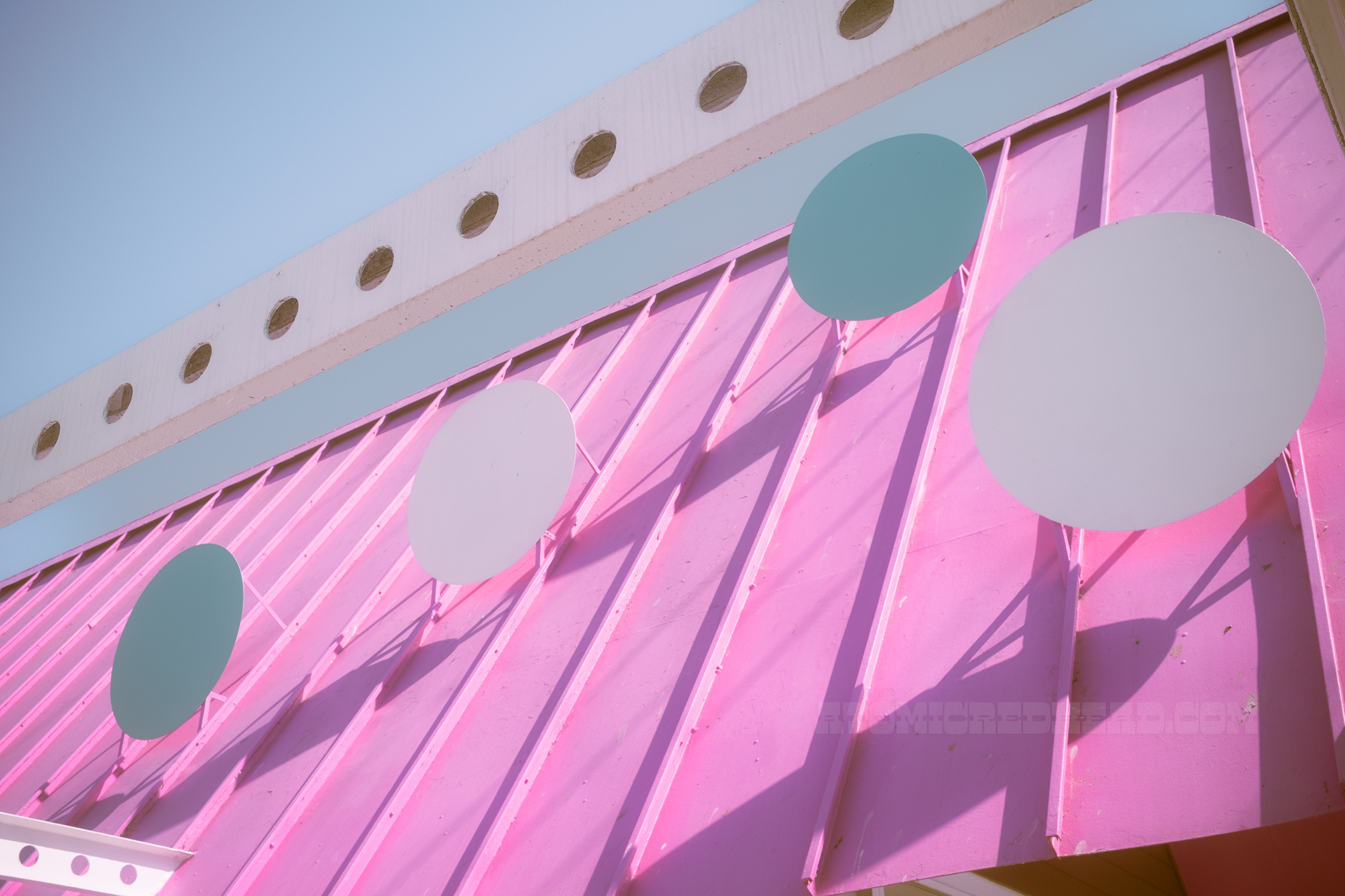 Close-up of the dots on the roof which are raised from the roof, across the front is a white beam with circles cut out.