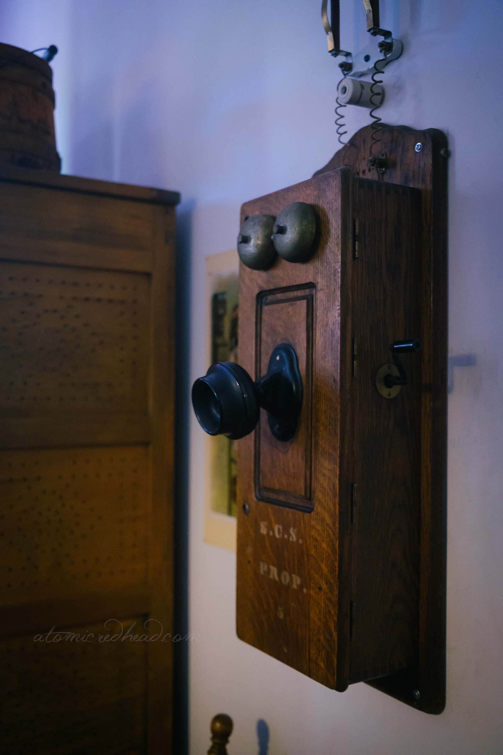 An antique telephone hangs on the wall.