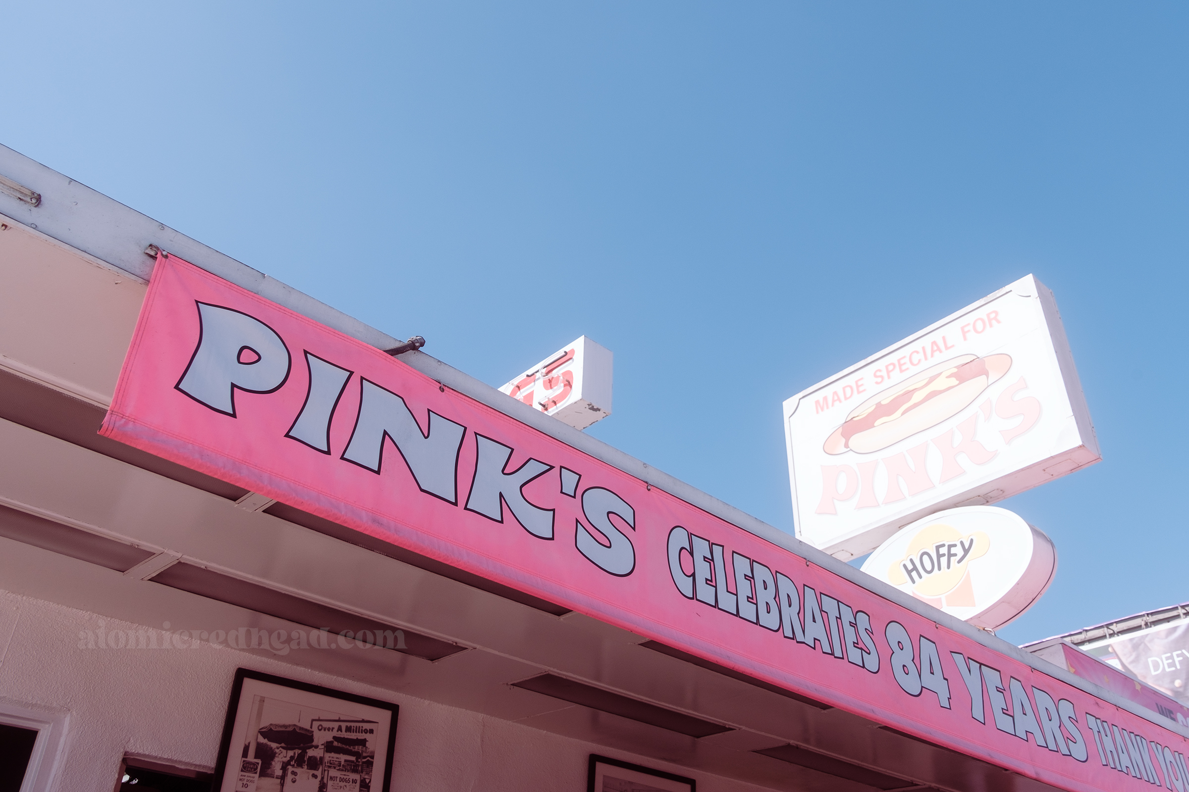A pink fabric banner hangs off the front awning and in bold white letters it reads "Pink's Celebrates 84 Years"