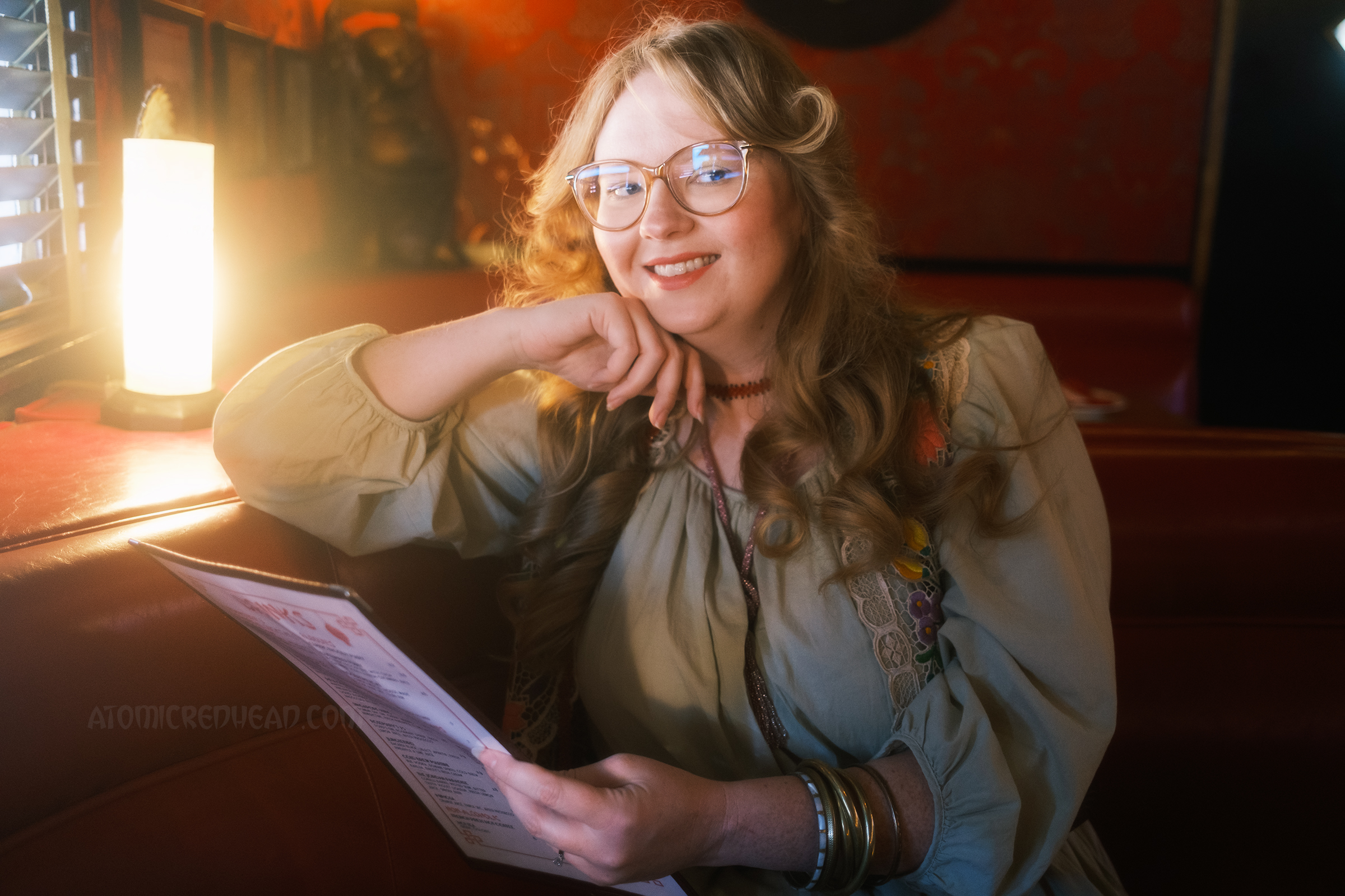 Myself seated in a booth holding the menu.