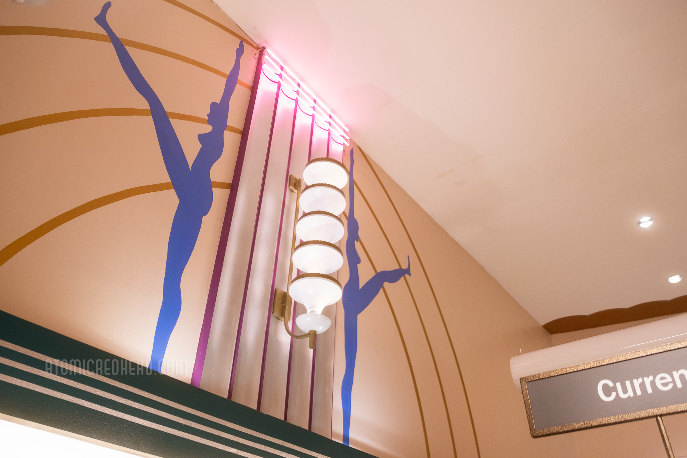 Blue female figures are painted on the walls, with tiered Streamline Modern light fixture.