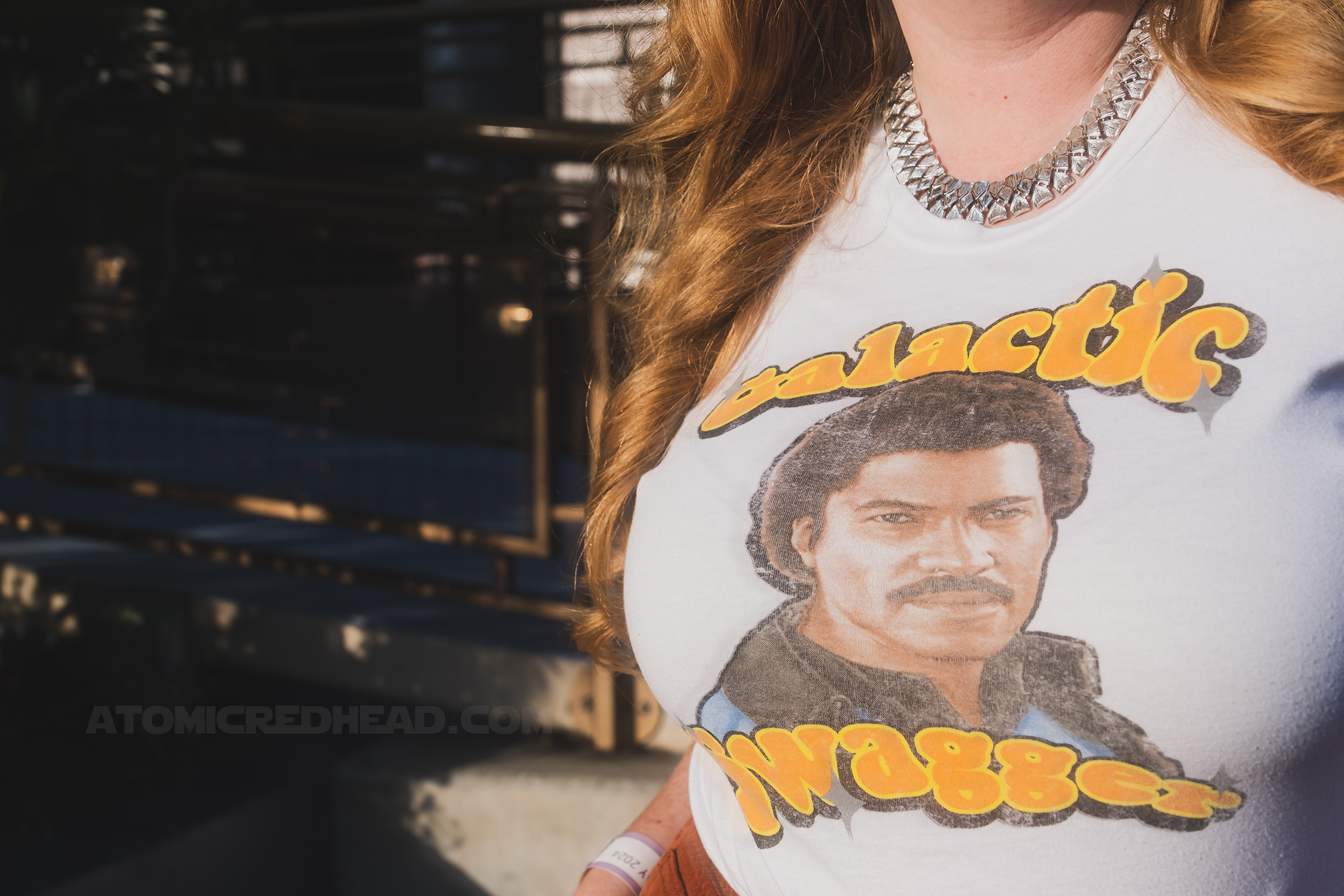 Close-up of my tee, which reads "Galactic Swagger" in bubbly groovy orange letters and features Lando's face in in the middle.