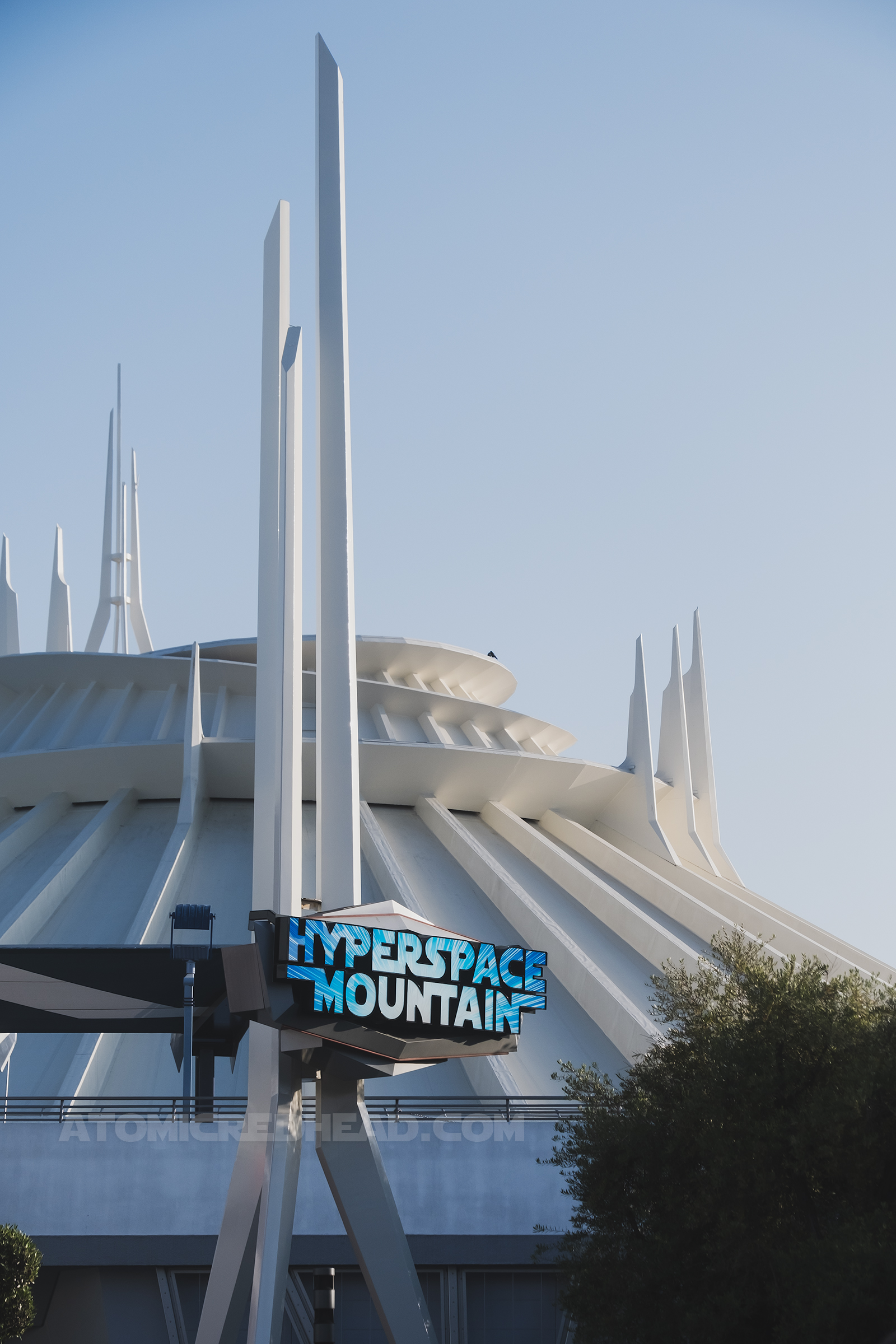View of the white spires of Space Mountain. The spire out front reads "Hyperspace Mountain" in blue letters.