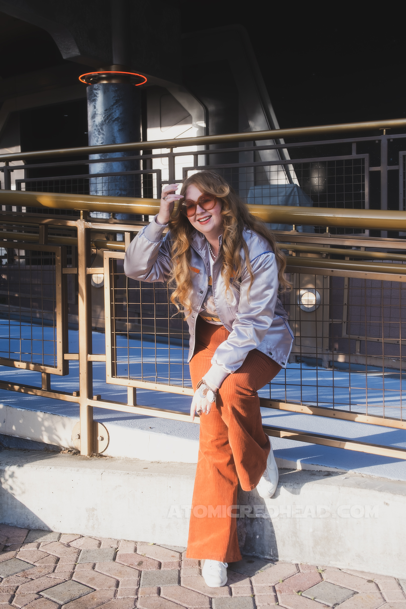 Myself, standing in Tomorrowland, wearing a silver jacket, a white tee featuring Lando reading "Galactic Swagger" and brown corduroy pants.