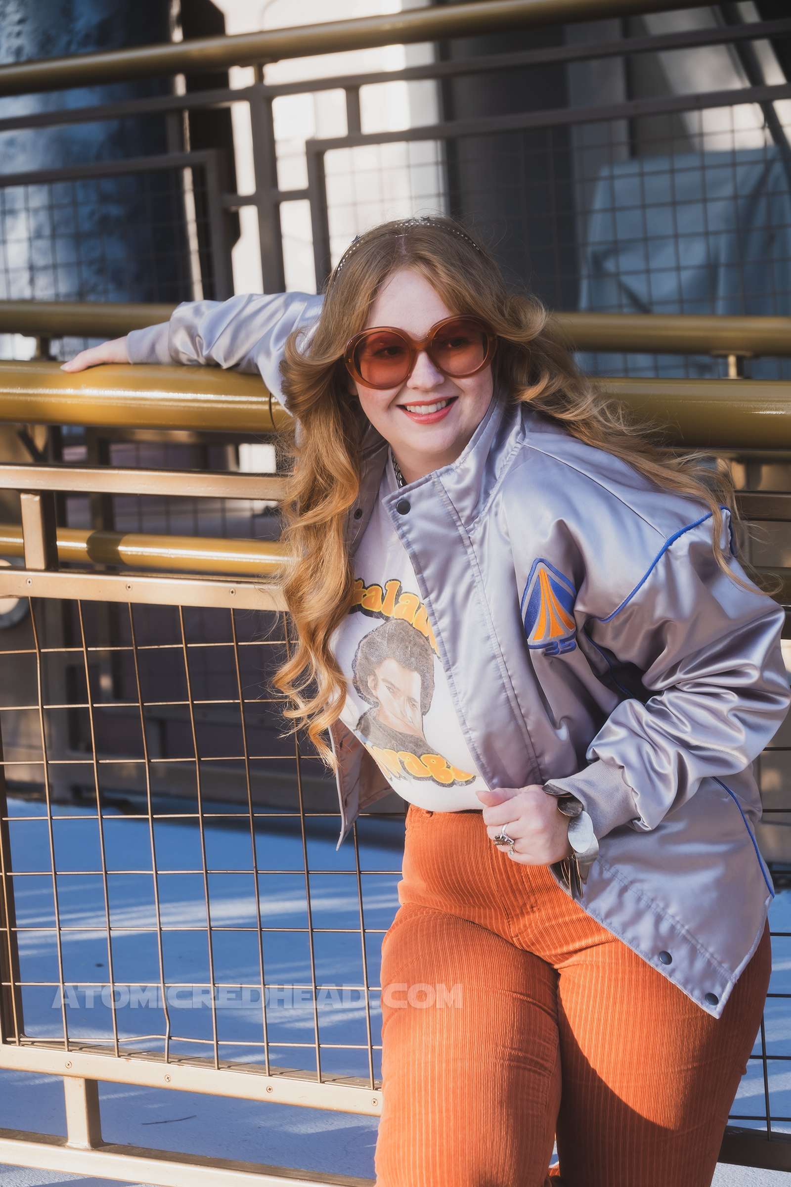 Myself, standing in Tomorrowland, wearing a silver jacket, a white tee featuring Lando reading "Galactic Swagger" and brown corduroy pants.