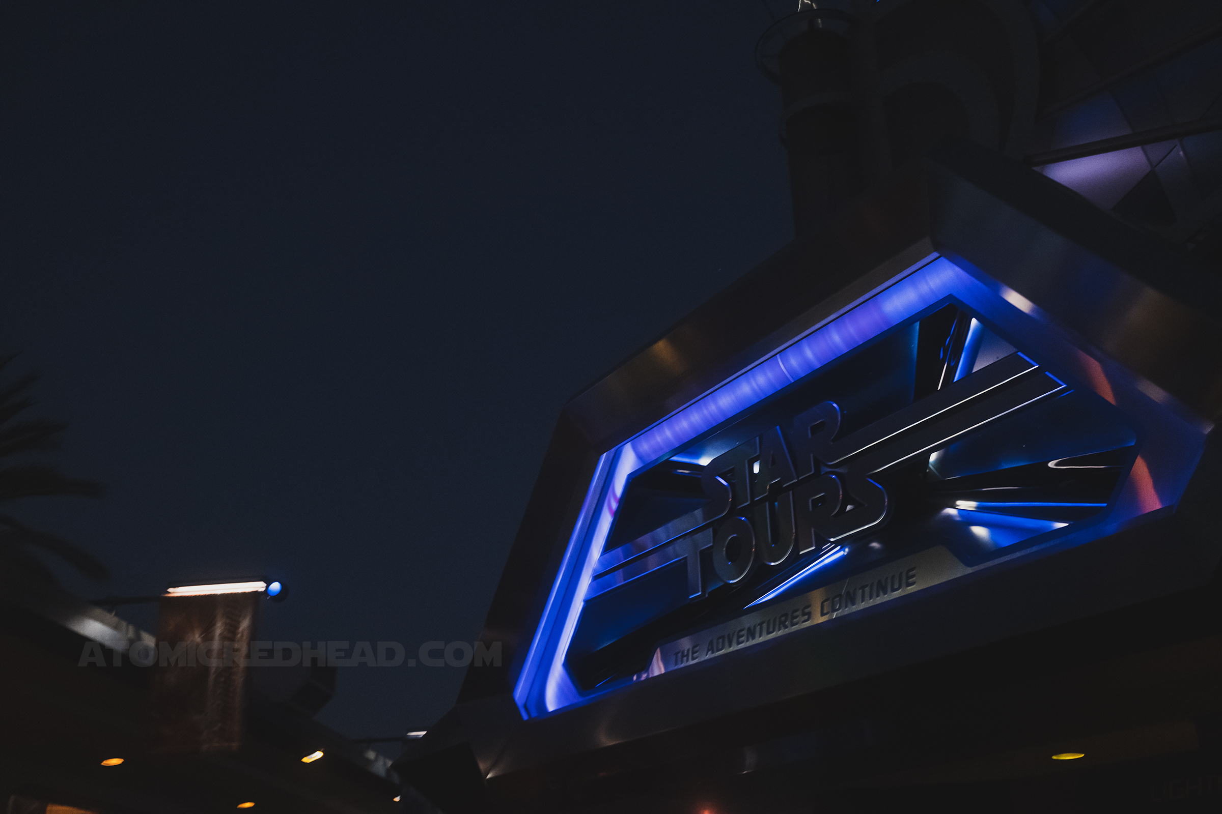 Sign for the Star Tours attraction, which reads "Star Tours The Adventure Continues" in silver letters.