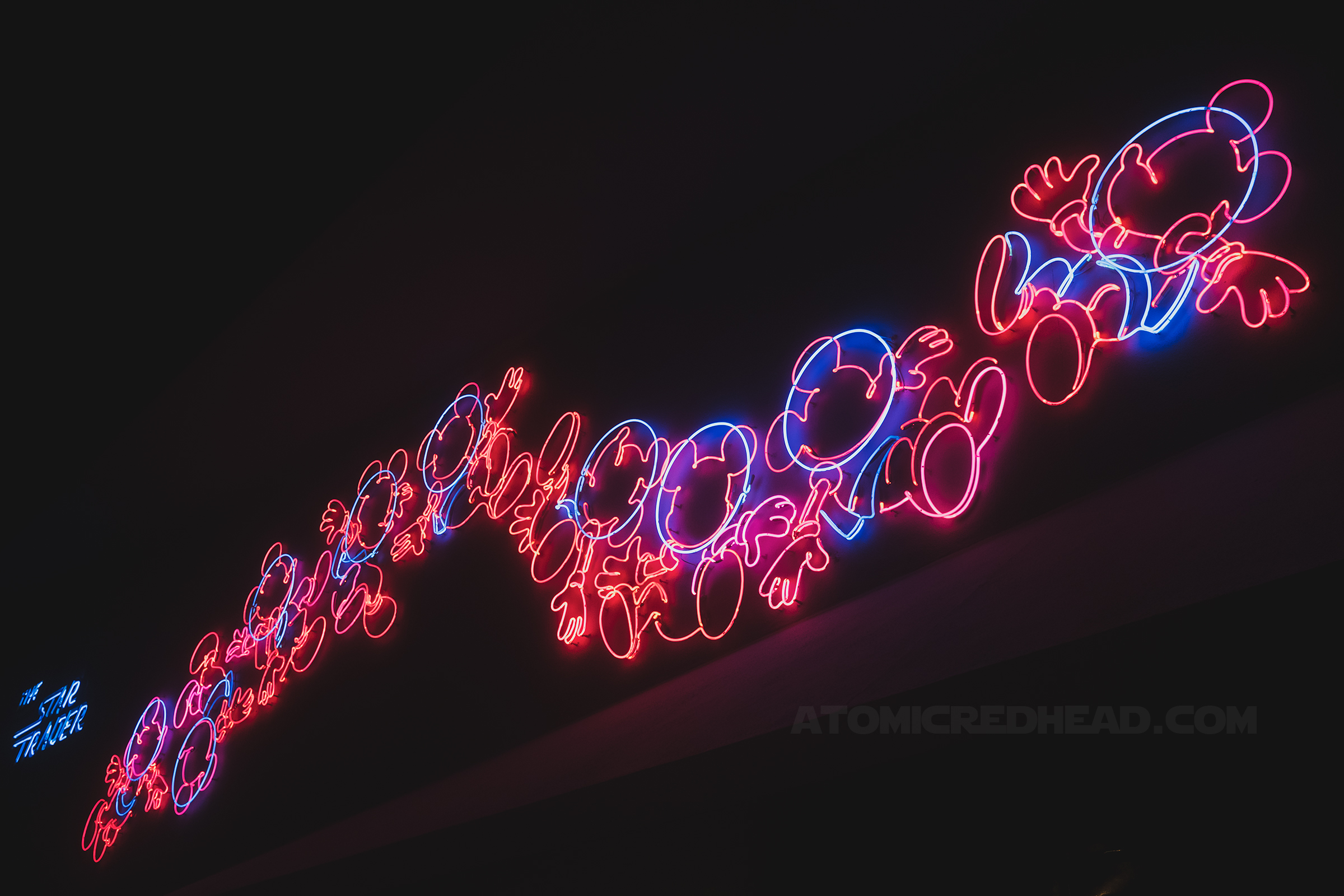 A pink and blue neon design of Mickey as an astronaut 