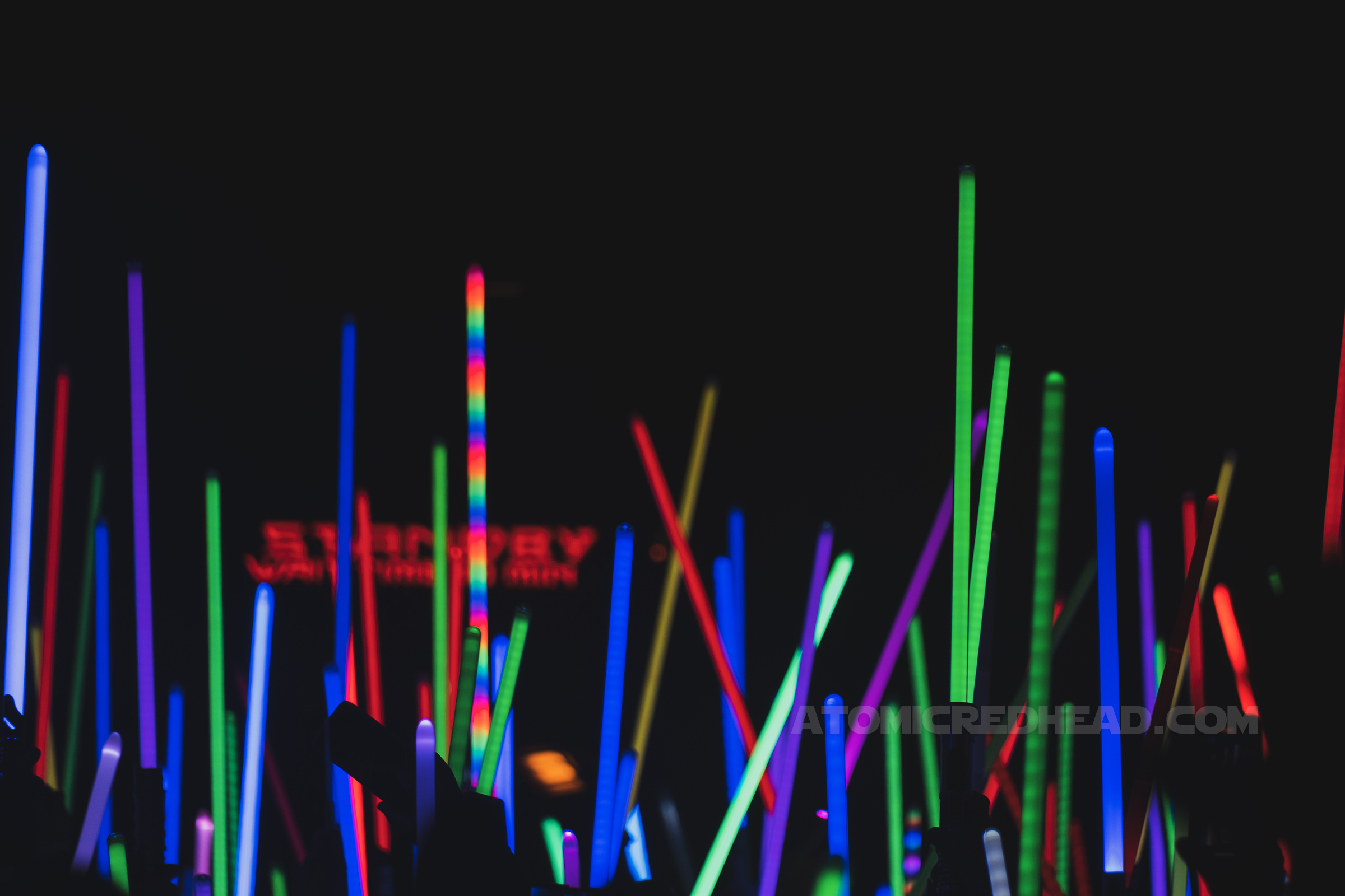 Lightsabers of various colors are hoisted high.