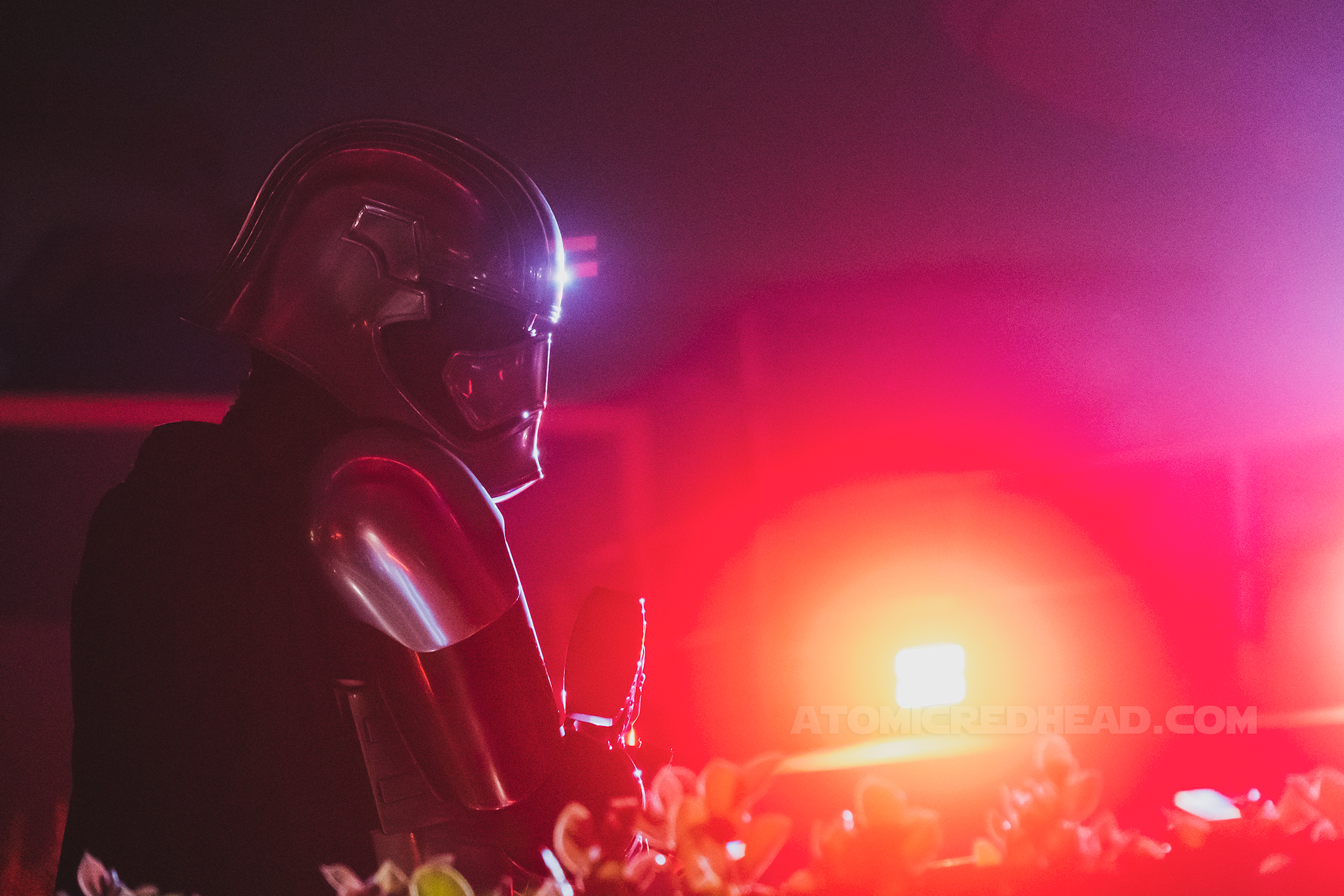Captain Phasma, lit with red light, looks over her shoulder.