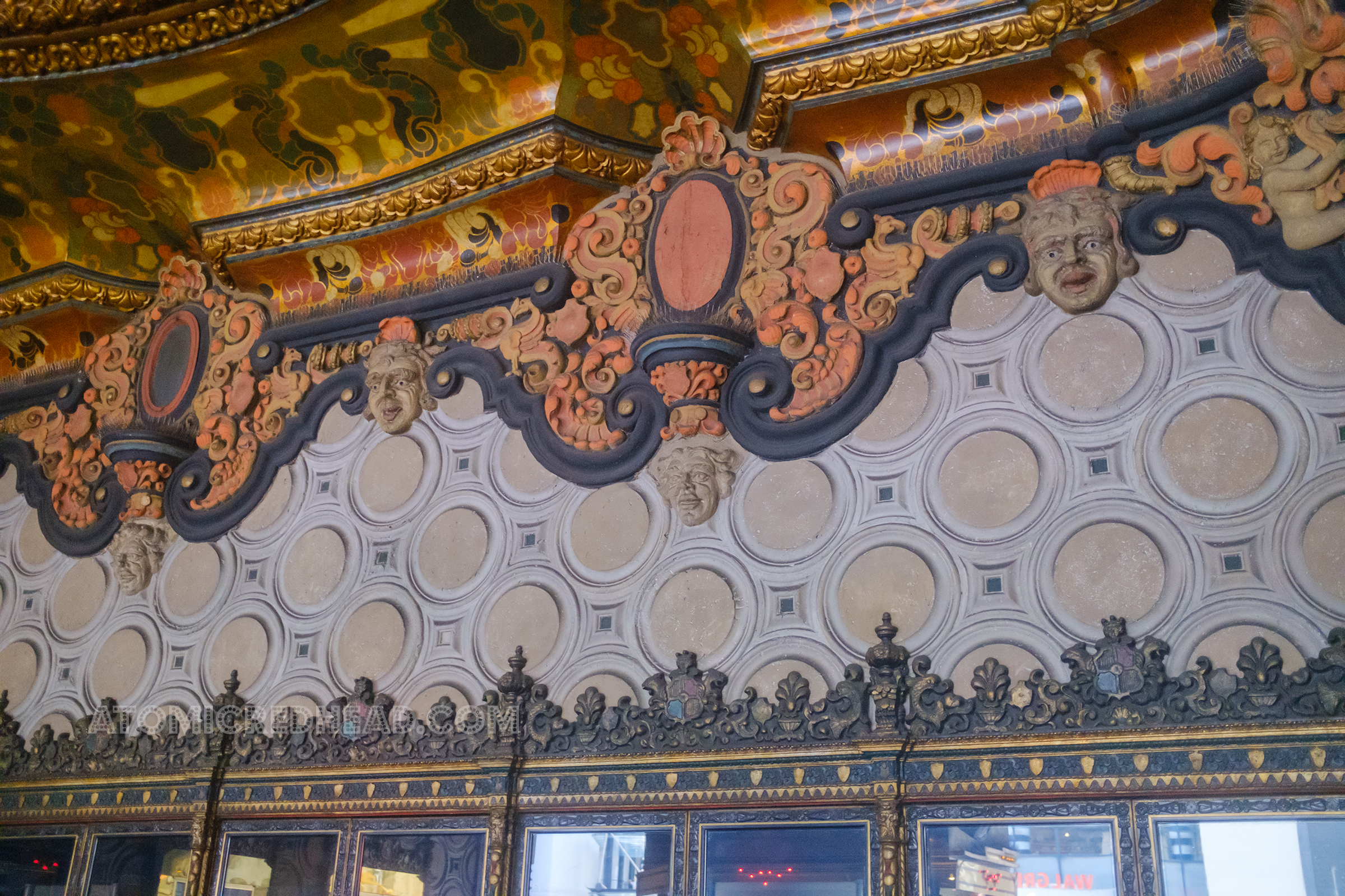 Pattern relief detail above the doorways, including circles, swirls, and more in black, orange, red, and gold.