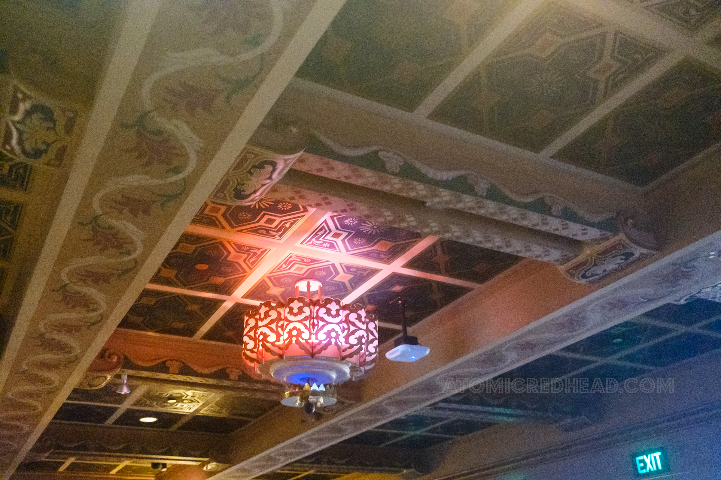 Interior light fixtures hang from the ceiling with an East Indian motief of swirls.