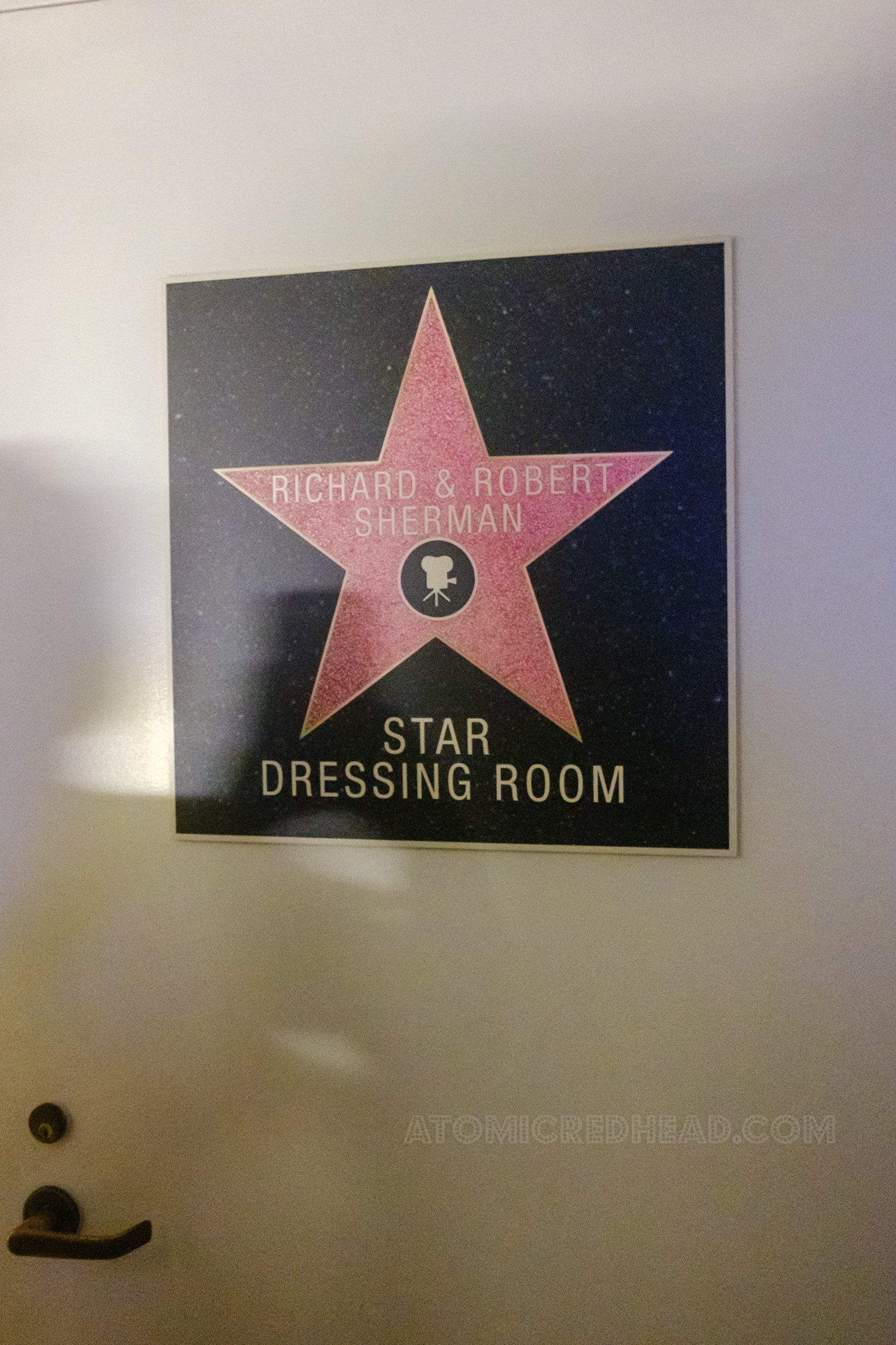 A white door features a framed pink star that reads "Richard & Robert Sherman" and below text reading "Star Dressing Room"