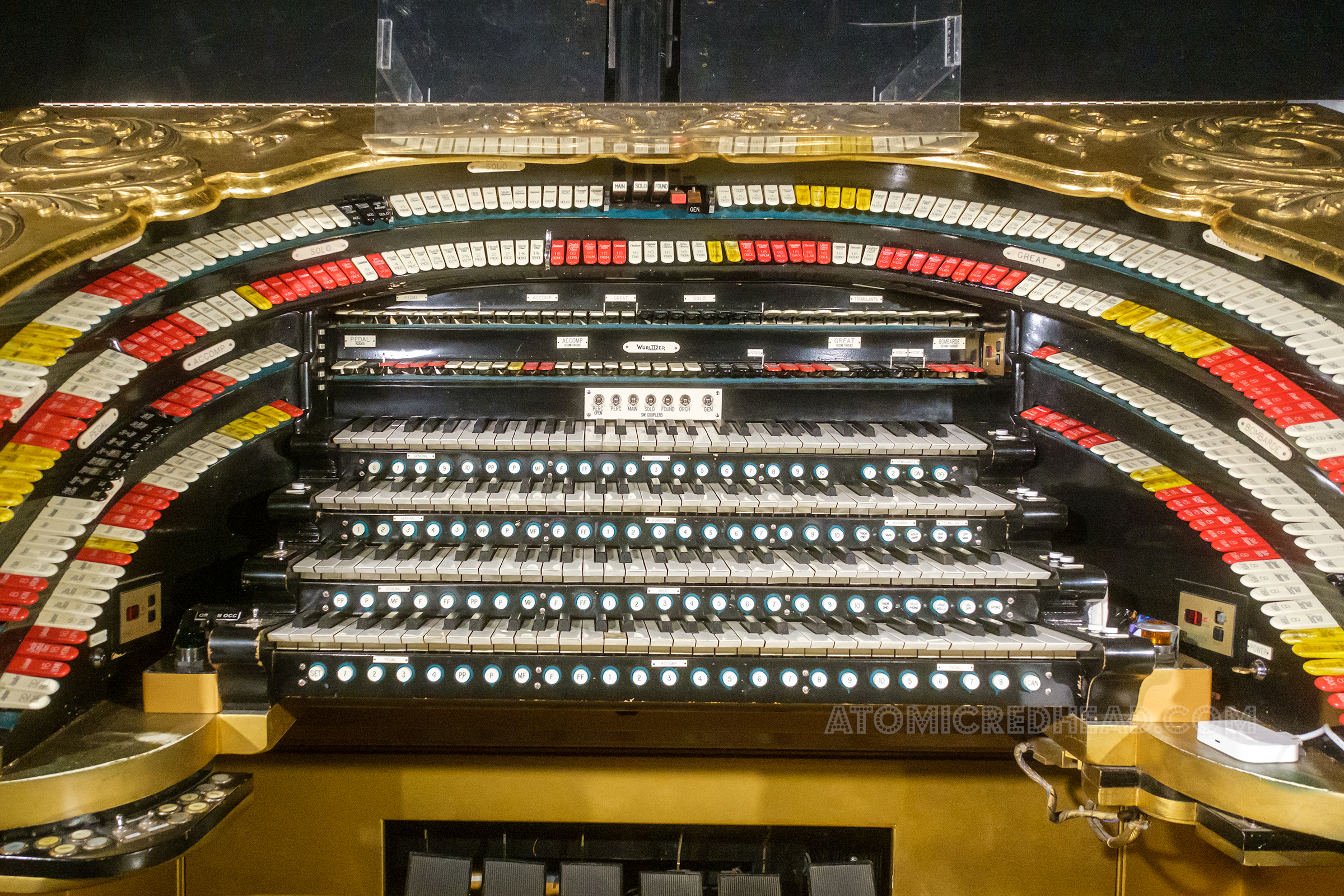 The keys of the massive Wurlitzer organ. The body of the organ features swirl details and is covered in gold leaf.
