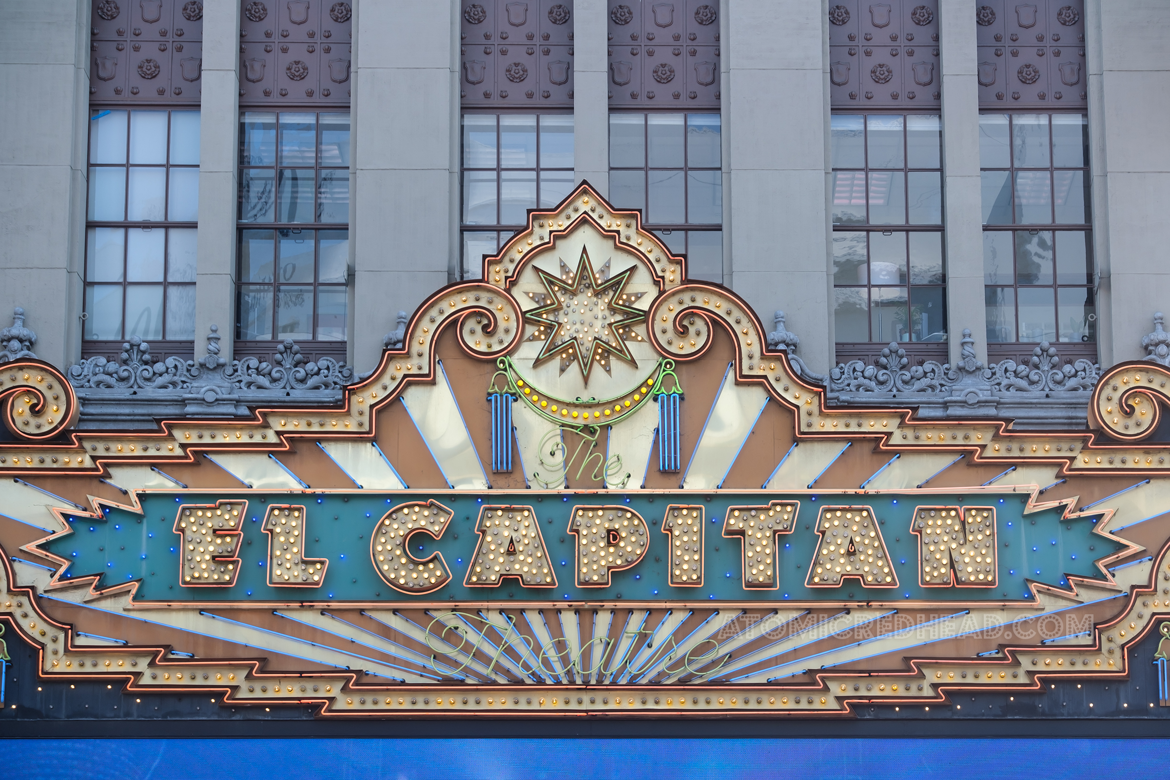 Close-up of the neon and bulbs above the marquee reading "The El Capitan Theatre"