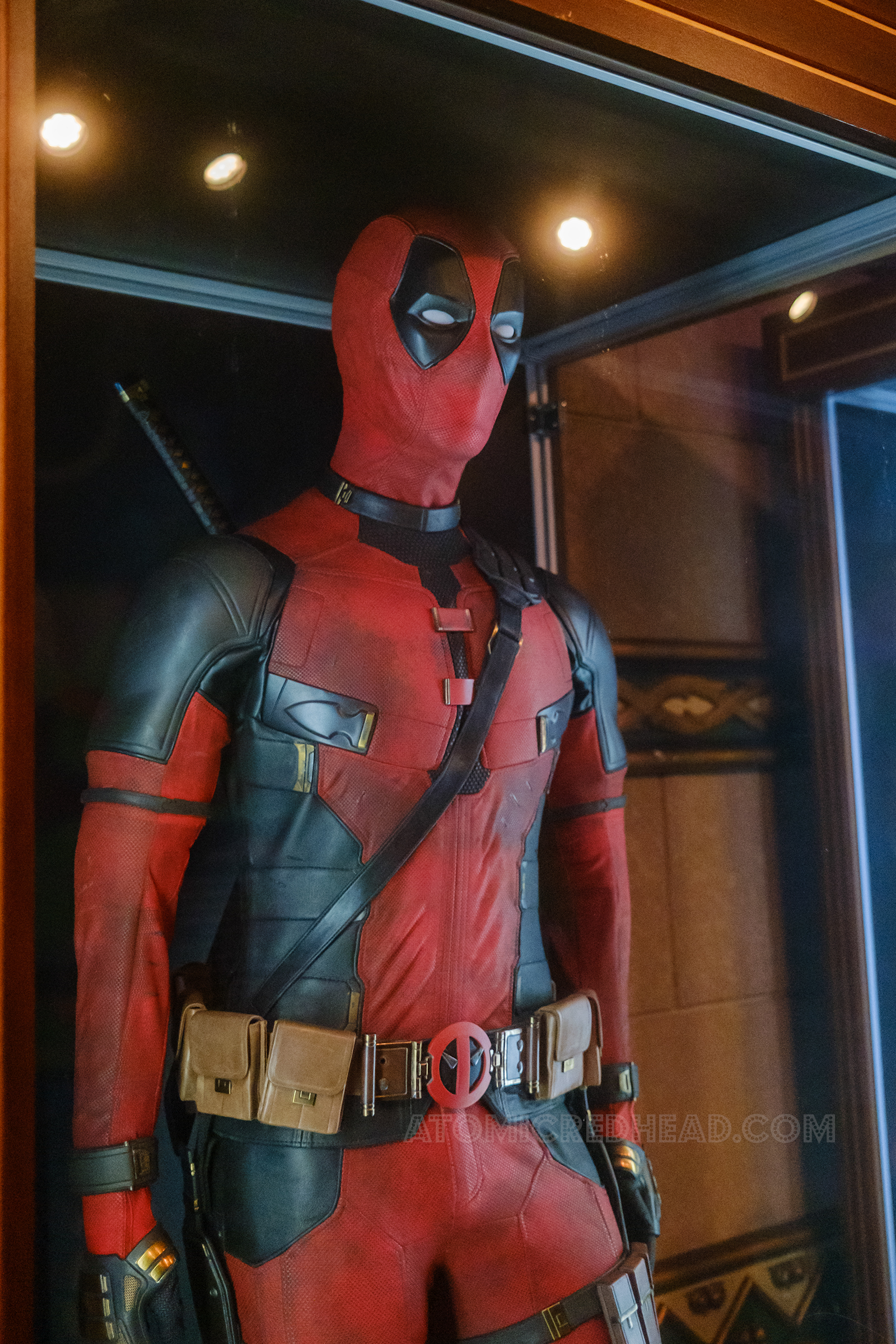 Deadpool costume of red and black in a display case in the lobby.