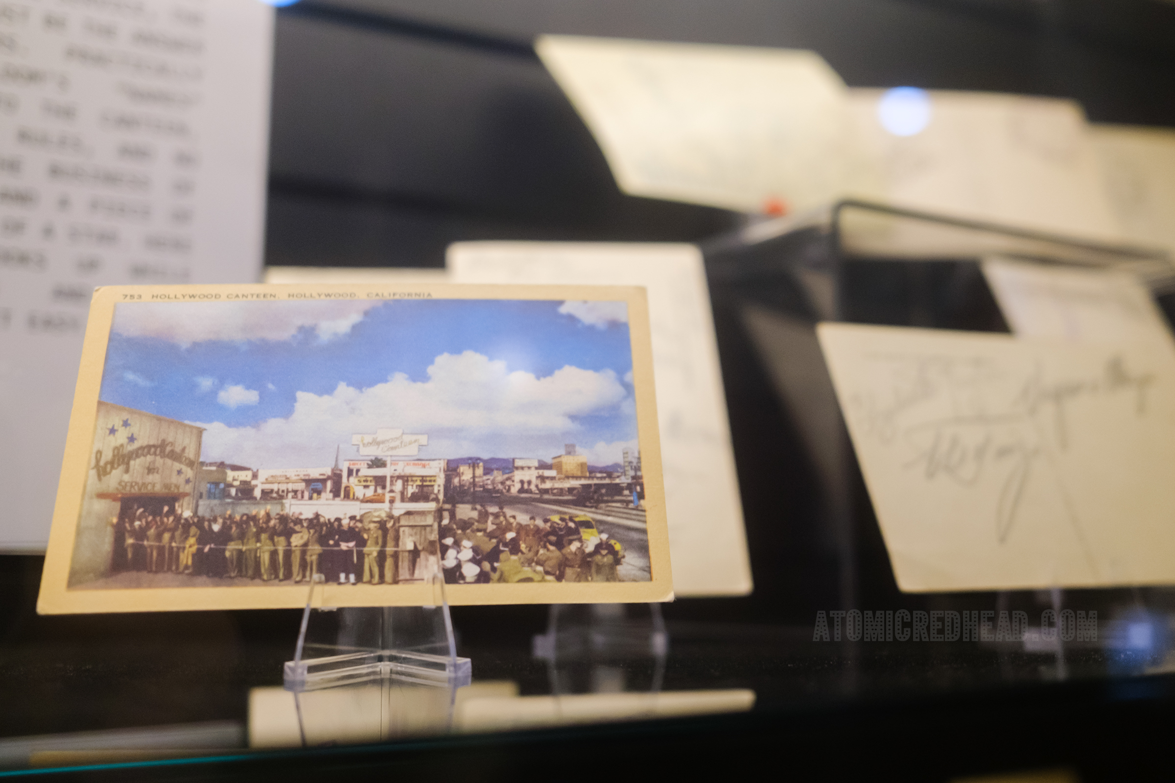 A postcard of the Hollywood Canteen with a line of service members out the door.
