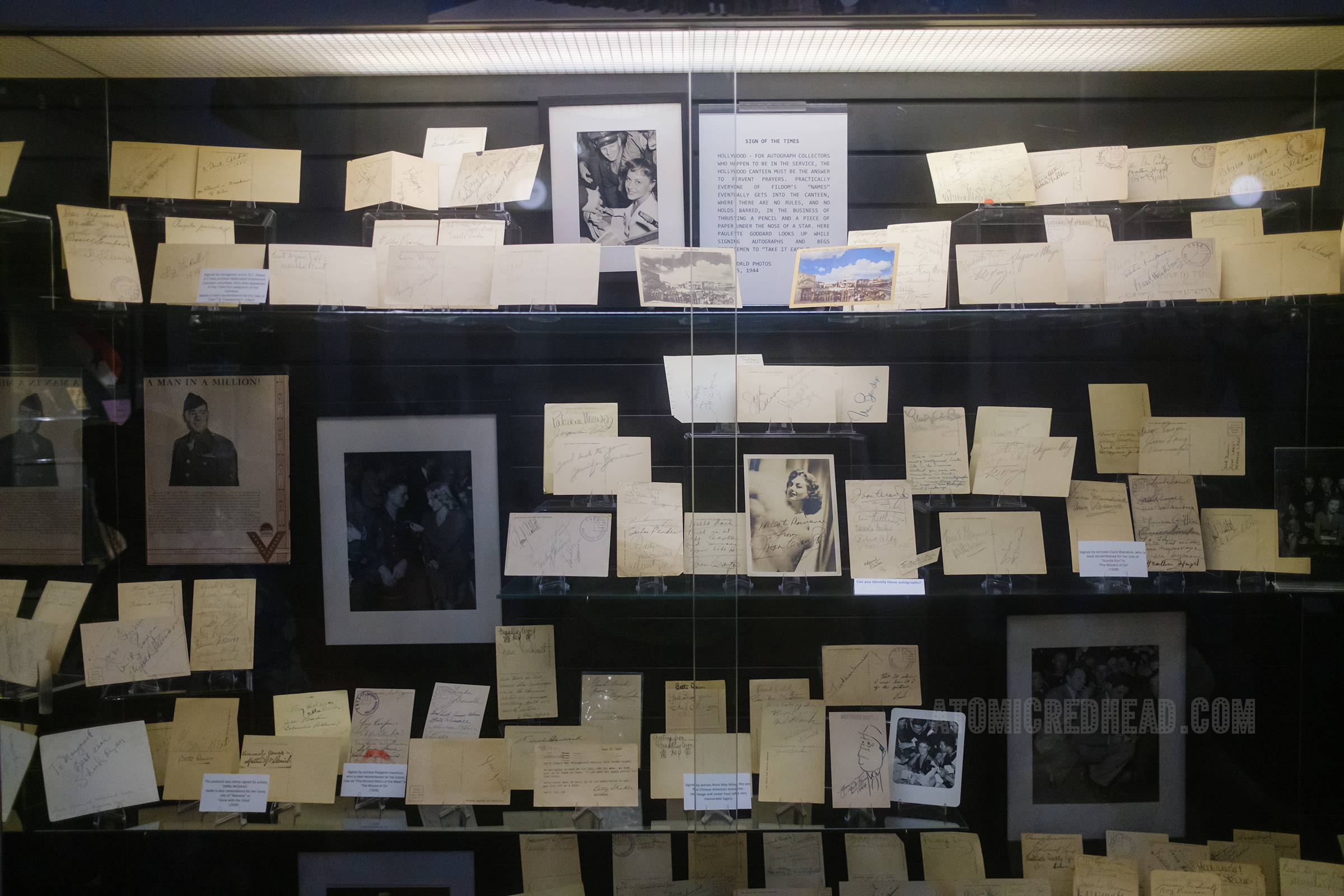 Large overview of the display case that houses a large collection of Hollywood Canteen postcards with autographs from the celebrities that would entertain service members.