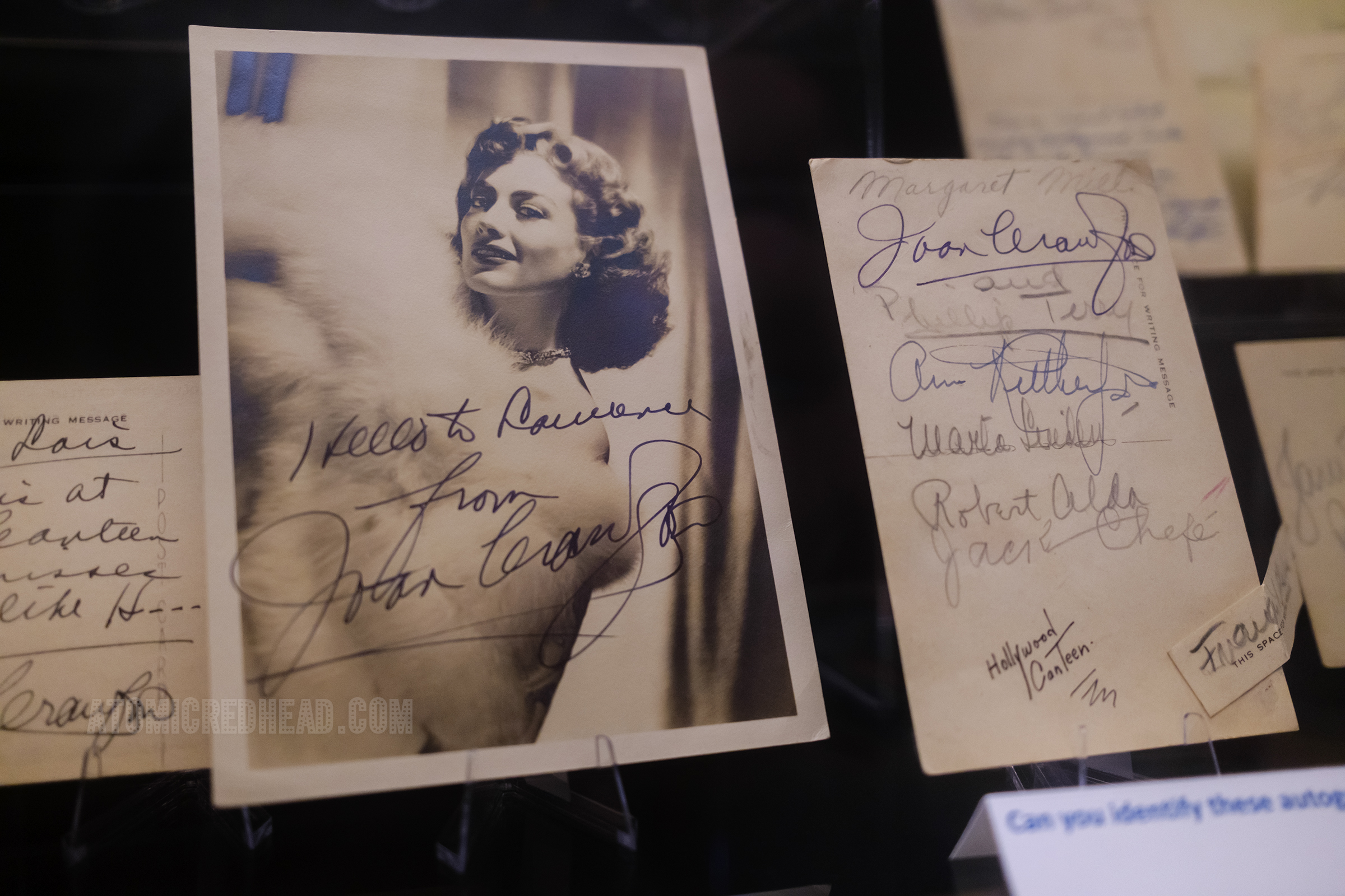 An autographed photo of Joan Crawford in a glamorous fur, her handwriting reads "Hello to the Canteen from Joan Crawford"