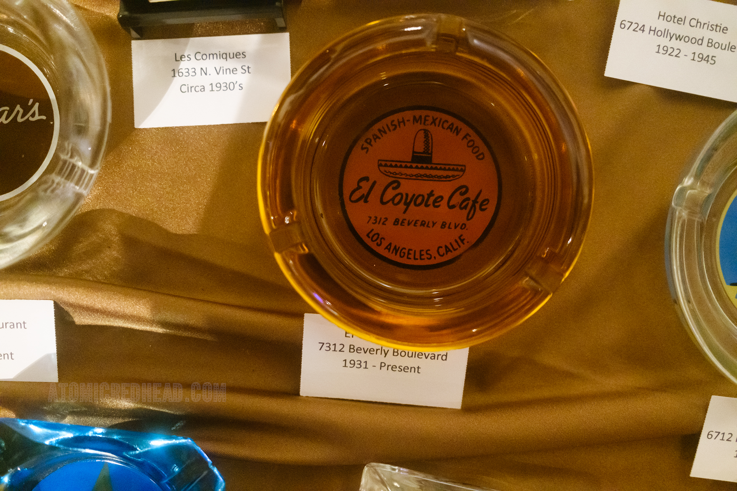 An ashtray from El Coyote. featuring an image of a sombrero, and text reading "Spanish-Mexican Food El Coyote Cafe 7312 Beverly Blvd. Los Angeles, Calif."