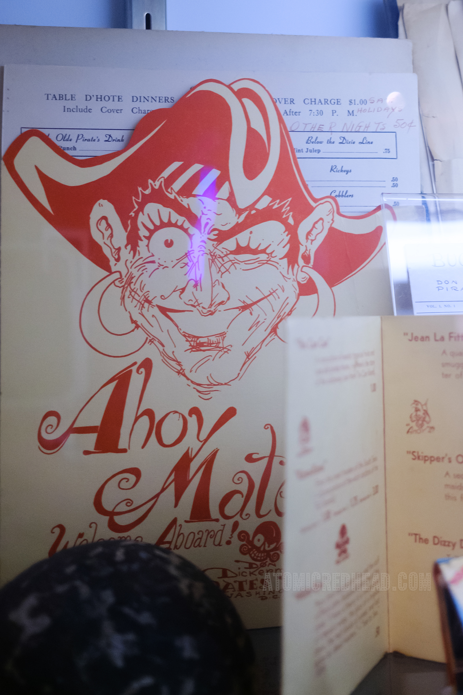 A red and white menu from The Pirate's Den, featuring an illustration of a pirate.