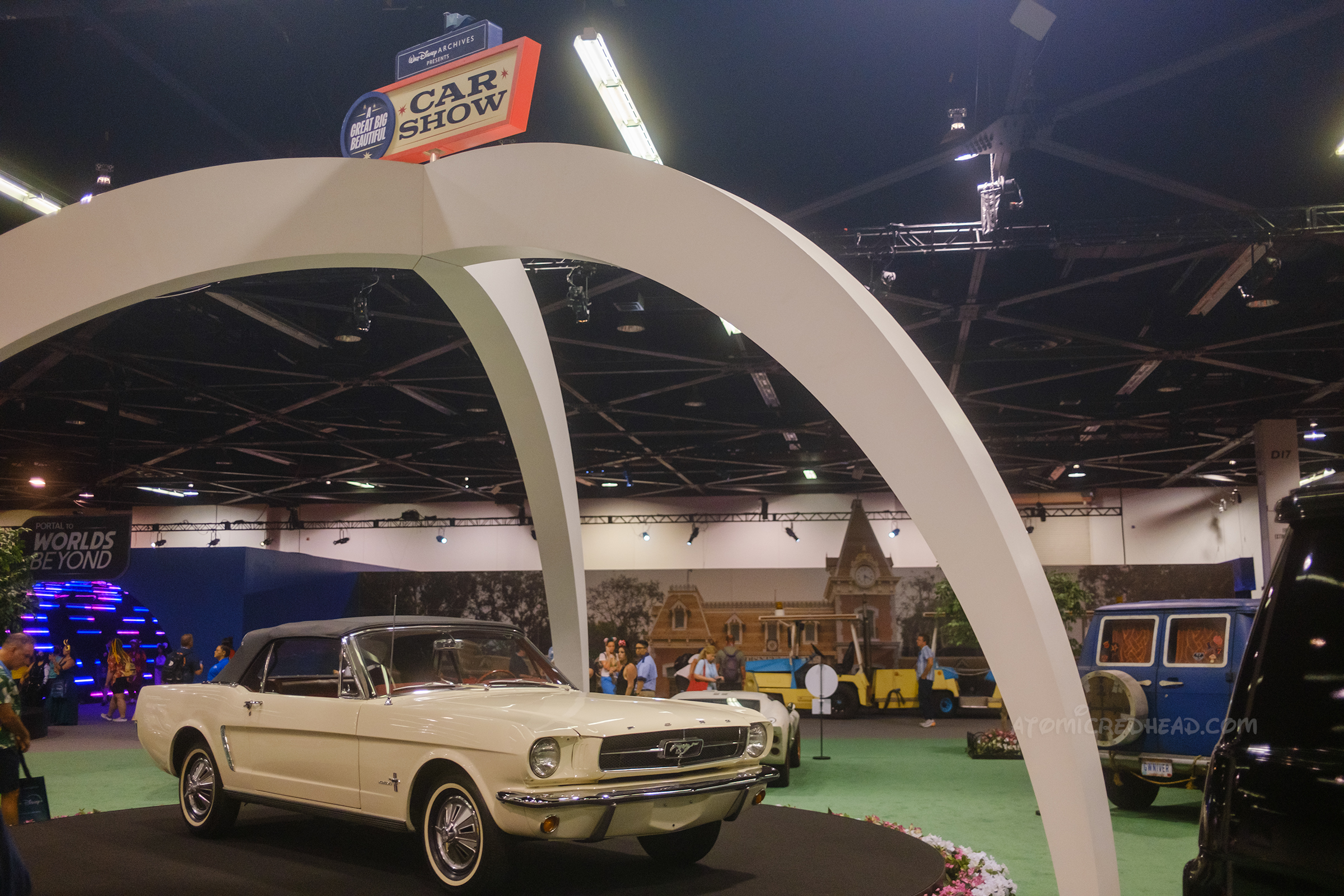 A white 1965 Ford Mustang Convertible rotates under an arch.