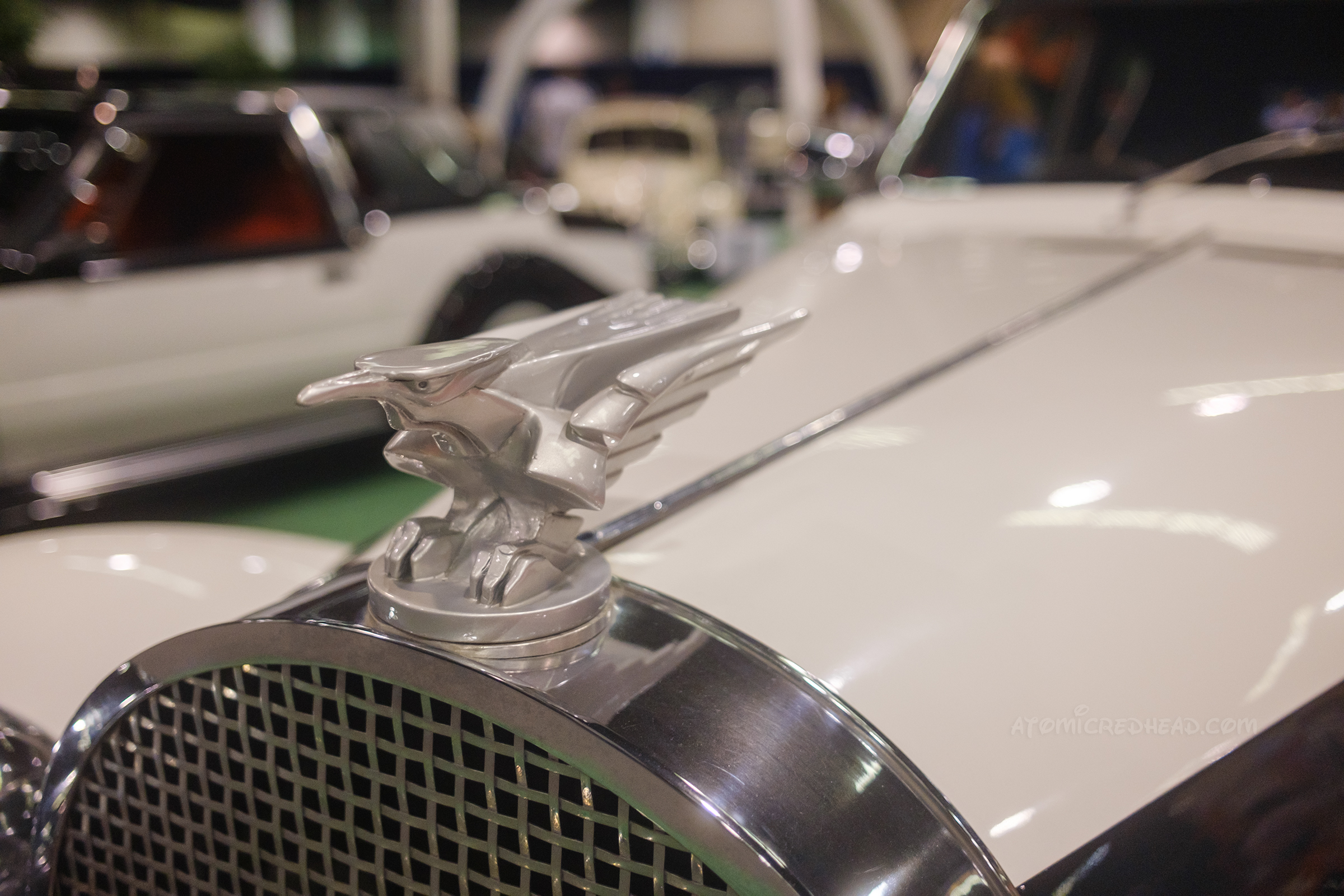 Close-up of an eagle or hawk that is the hood ornament on one of the Cruella cars.