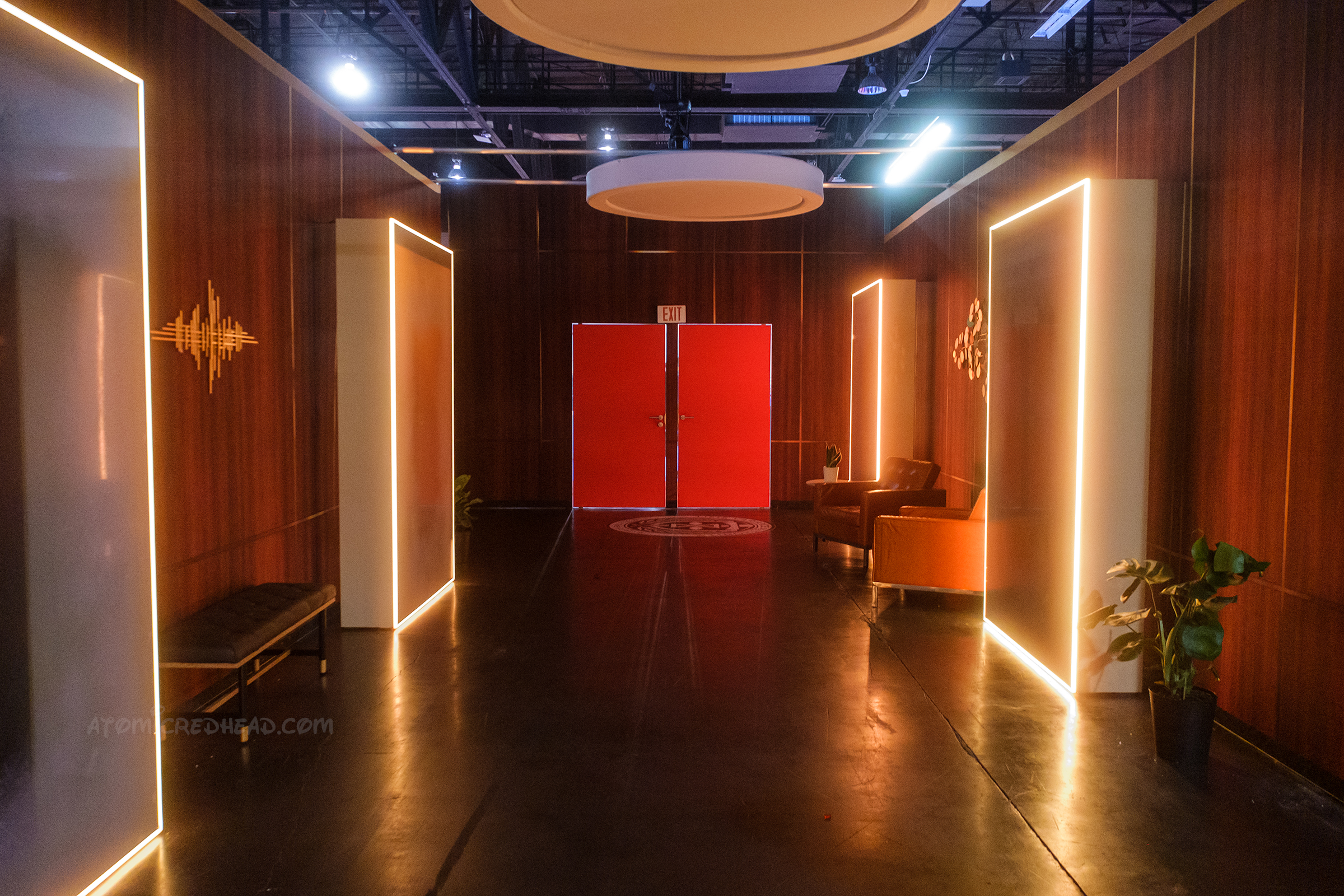 A hallway of wood panel walls and illuminated doorways known as "Time Doors"
