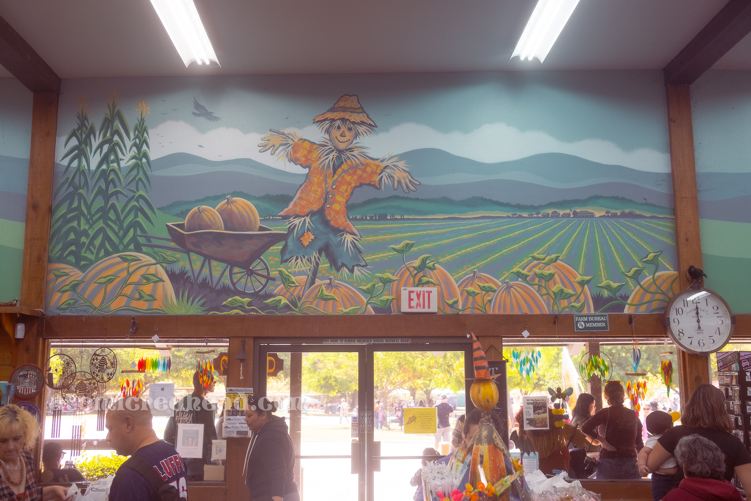 Mural above the doors, with a scarecrow and a field behind.