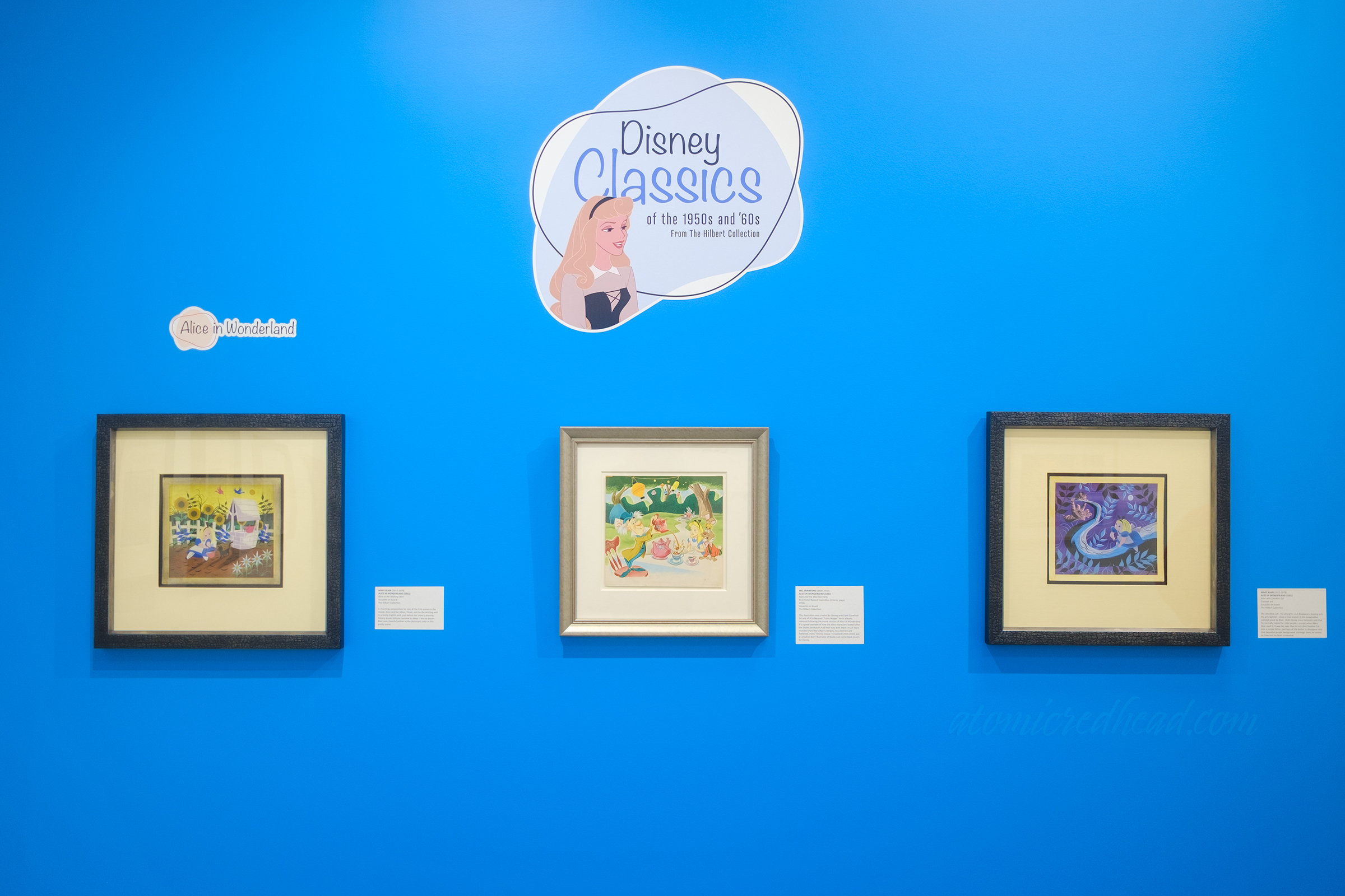Overall view of a wall with art from Alice in Wonderland. Atop it reads "Disney Classics from the 1950s and '60s"