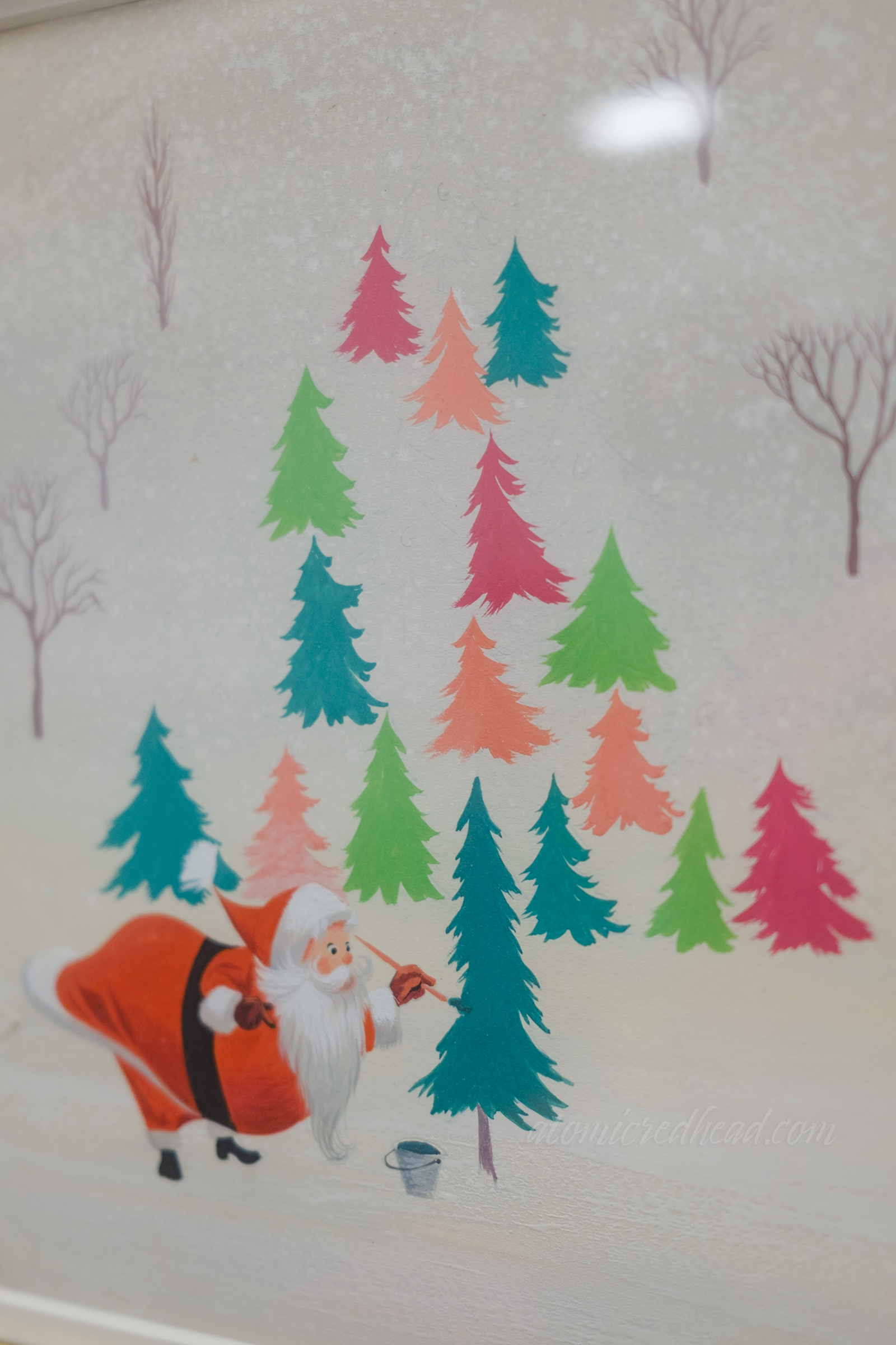 Santa paints trees various colors, including teal, bright green, and pink.
