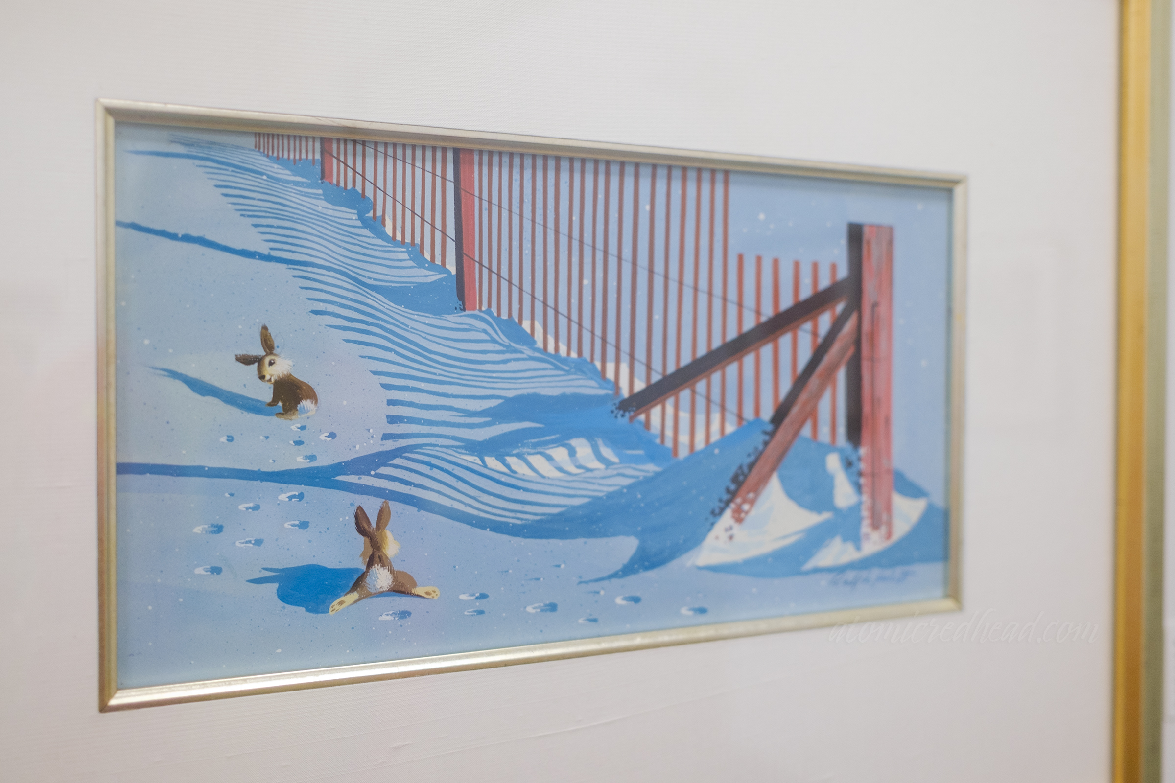 Two bunnies hop through the snow.