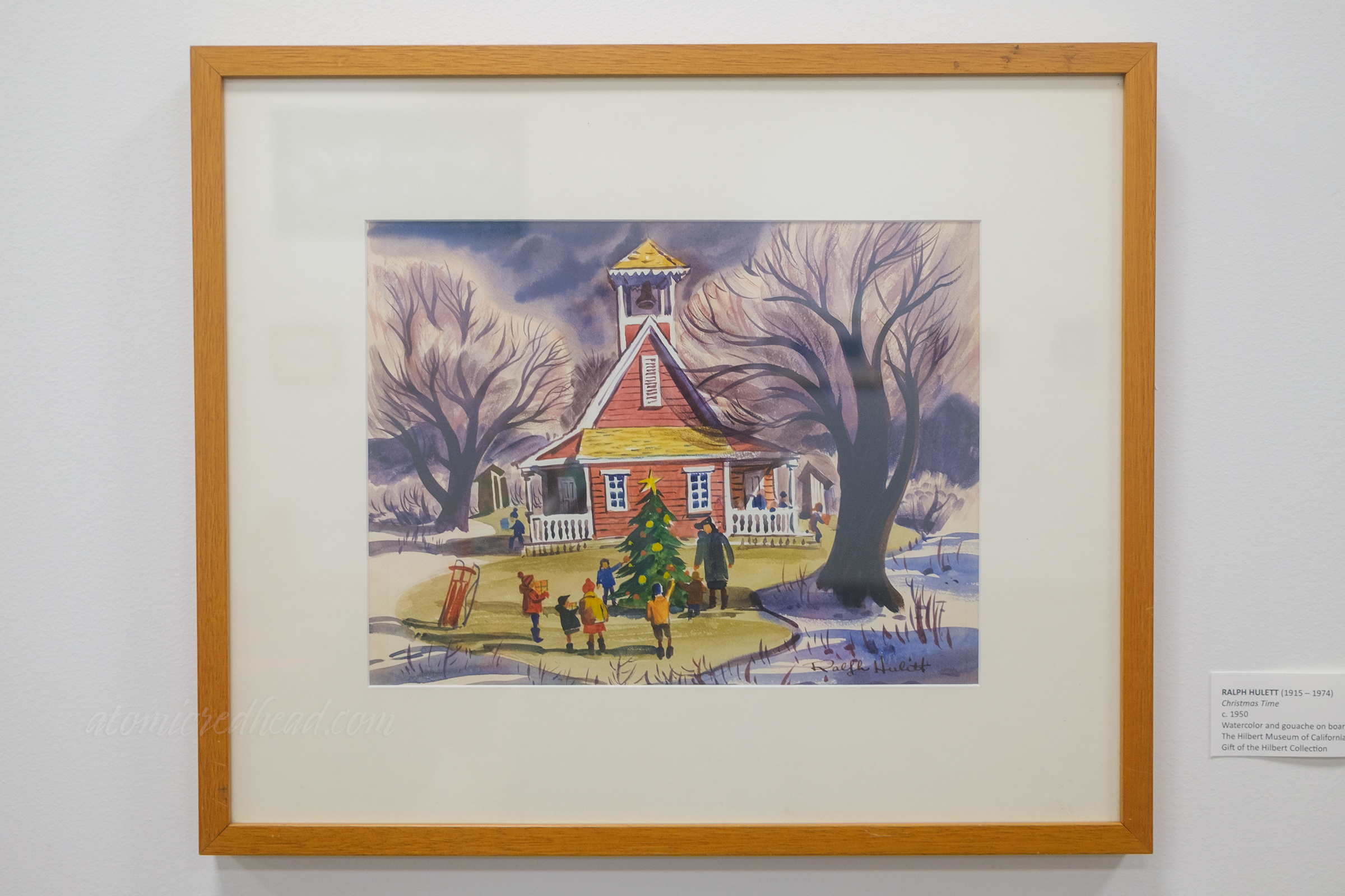 Painting of a group of children around a Christmas tree outside of a red school house.