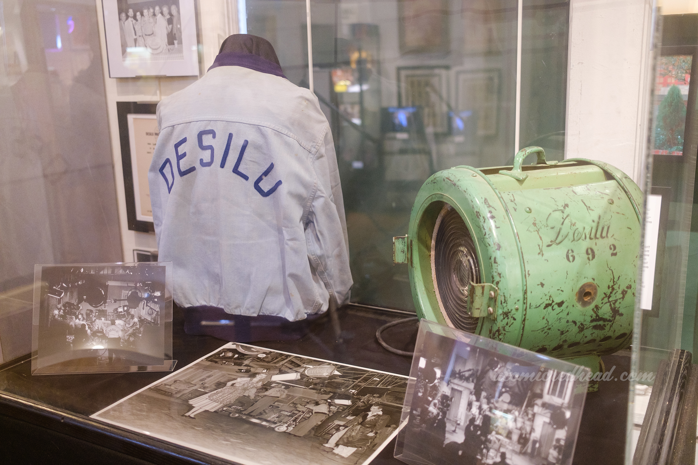 A light blue jacket reads "Desilu" in darker blue, worn by the crew, on the left a green stage light reads "Desilu" in script, used on the soundstage.