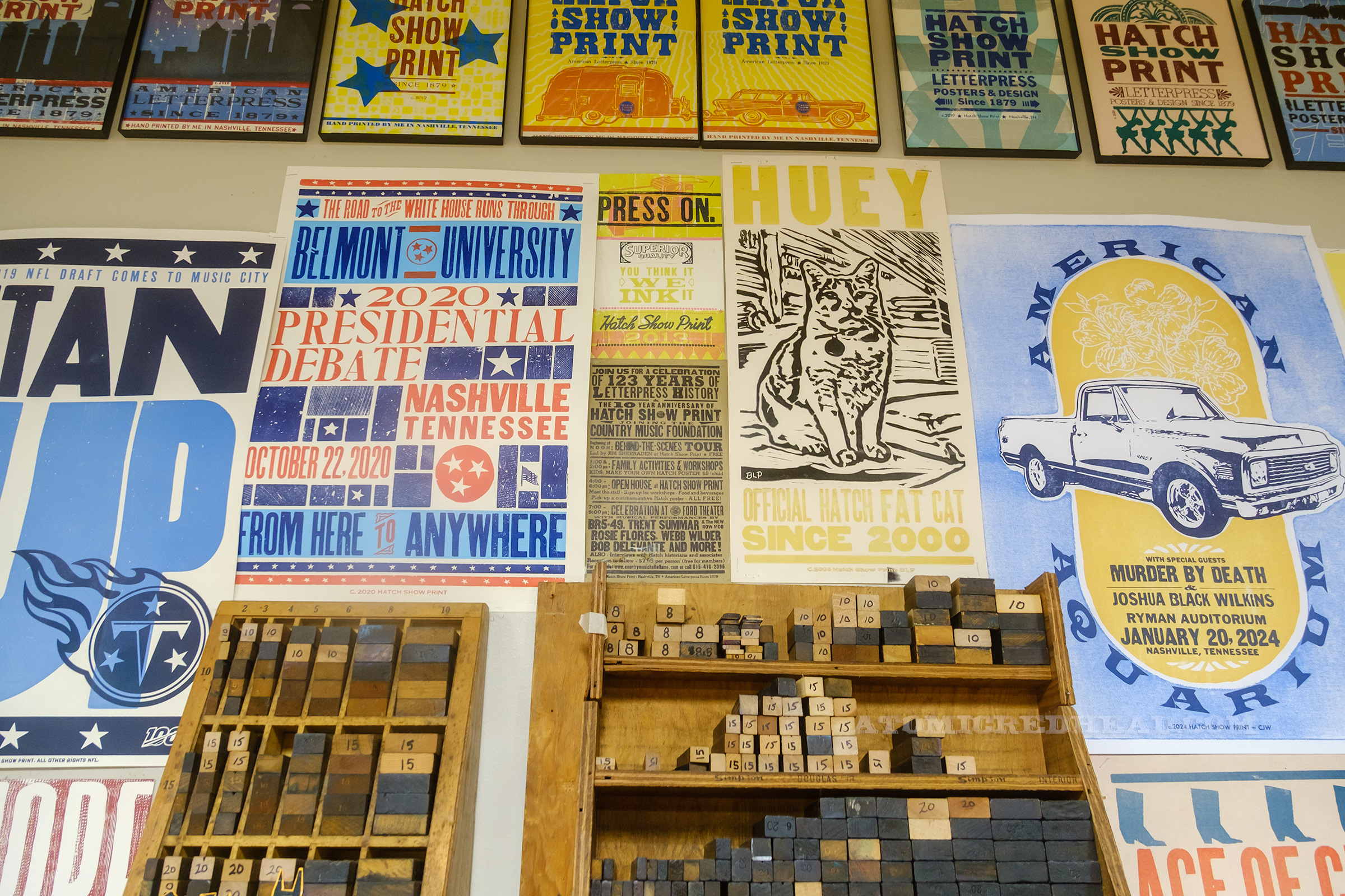 Inside of the classroom, with walls covered in a variety of posters, along with shelves with printing blocks.