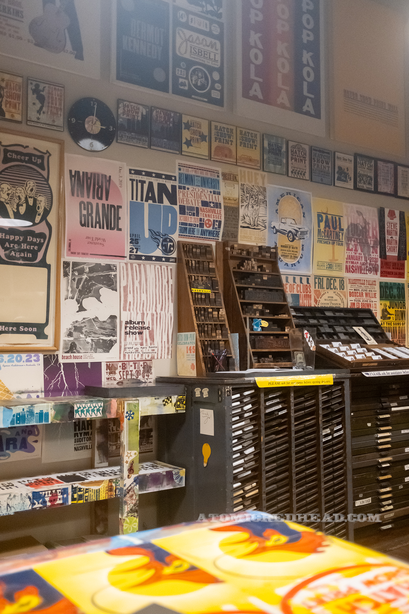 The classroom, the walls of which are covered in more recent posters, along with some small shelving with blocks on them.