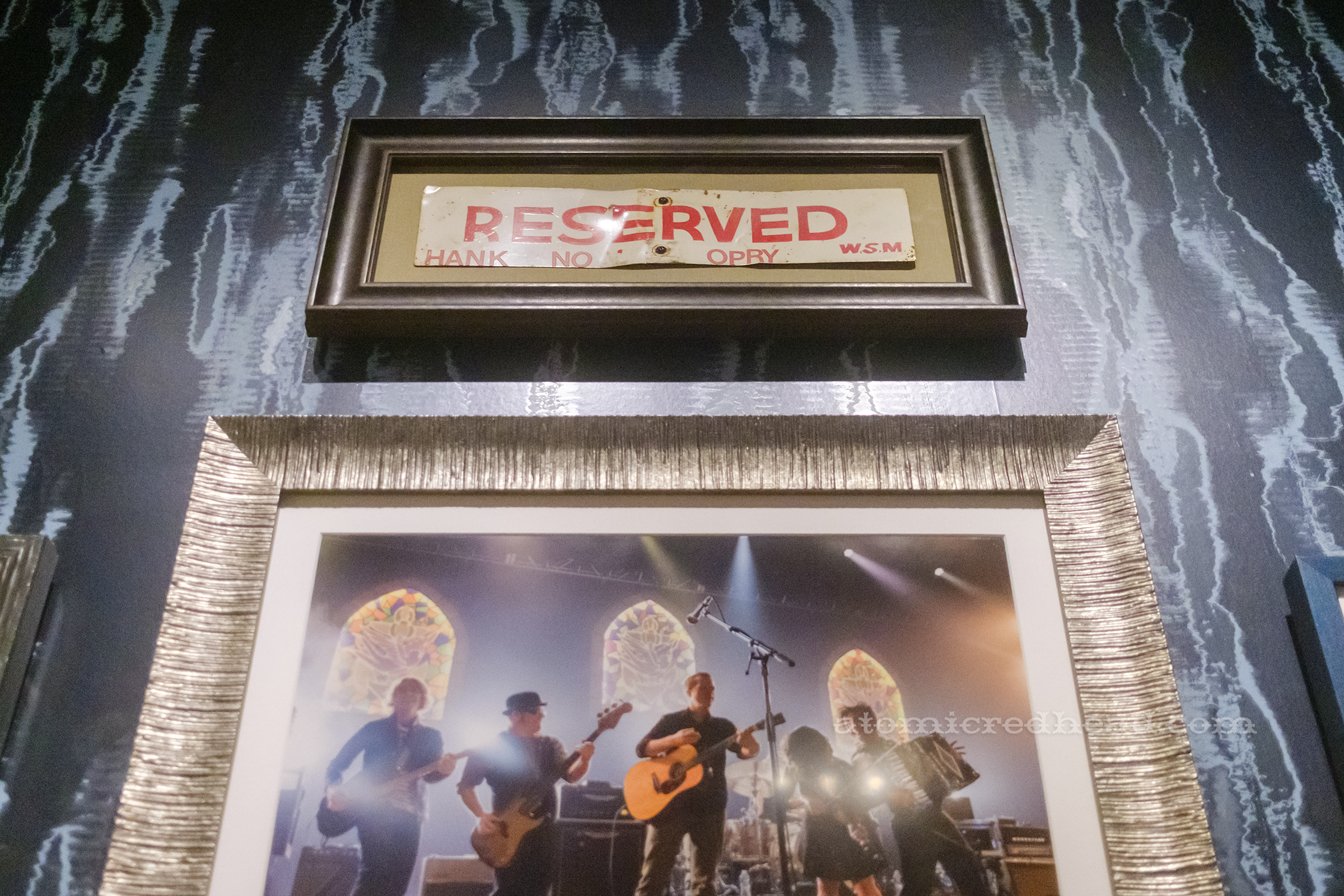 A framed red and white sign reads "Reserved Hank Snow Orpy WSM" however the S and W are missing.