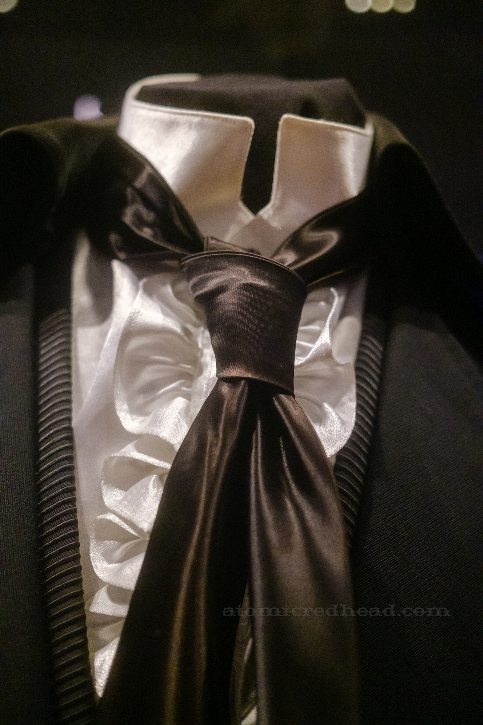 Close-up of a black tie in a black ensemble worn by Johnny Cash.