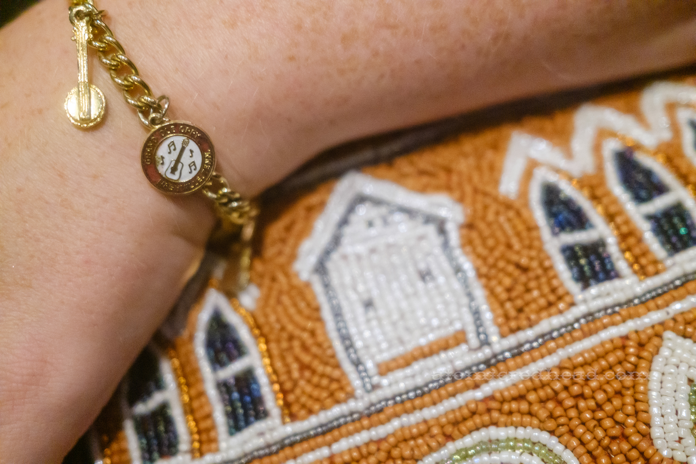 Close-up of my charm bracelet, that features an enamel charm reading "Grand Ole Opry Nashville Tennessee" with crossed guitar and banjo, and a charm of a banjo