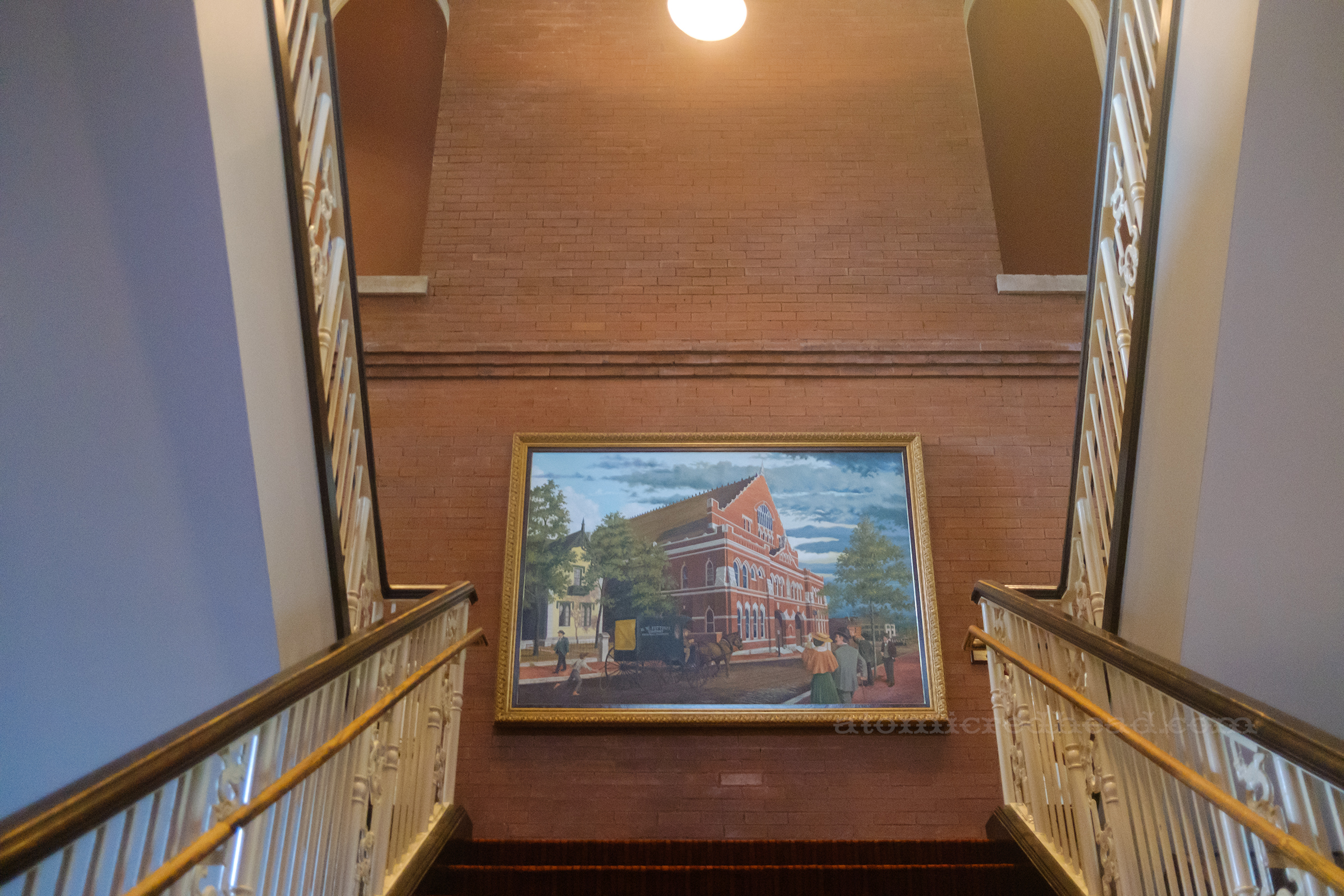 A large painting of the exterior of the Ryman, a large brick building 
