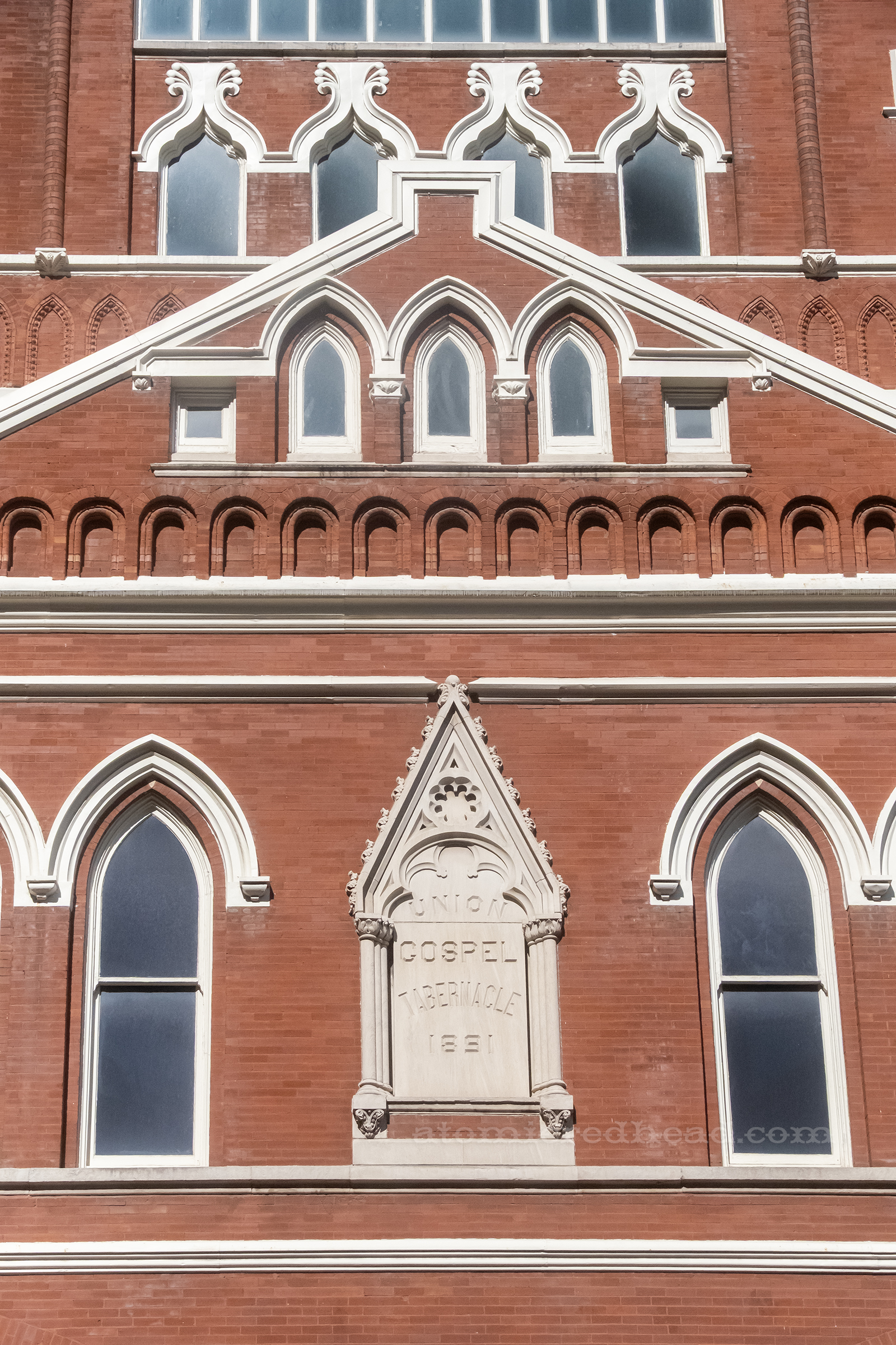 Exterior view of the Ryman, a multi story brick building with white details and a peaked roof.