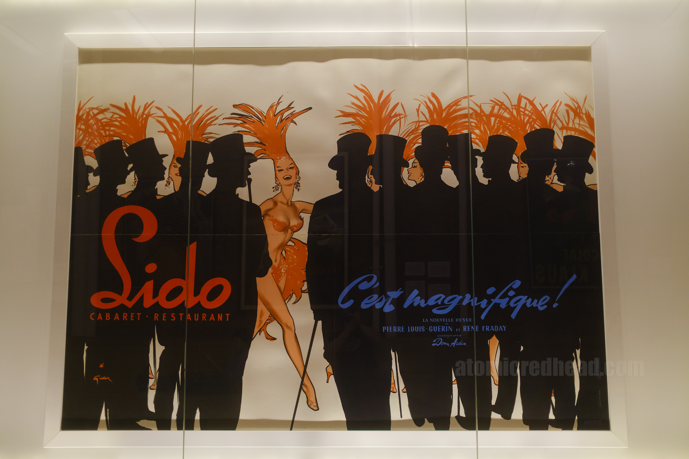 A large poster with silhouettes of men and a showgirl in the middle, advertising the Lido show.